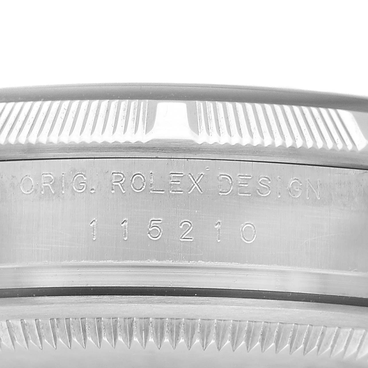 The image shows the side of a Rolex Date 115210 Men's Stainless Steel Black Dial model watch, highlighting the engraved design and model number on the case.