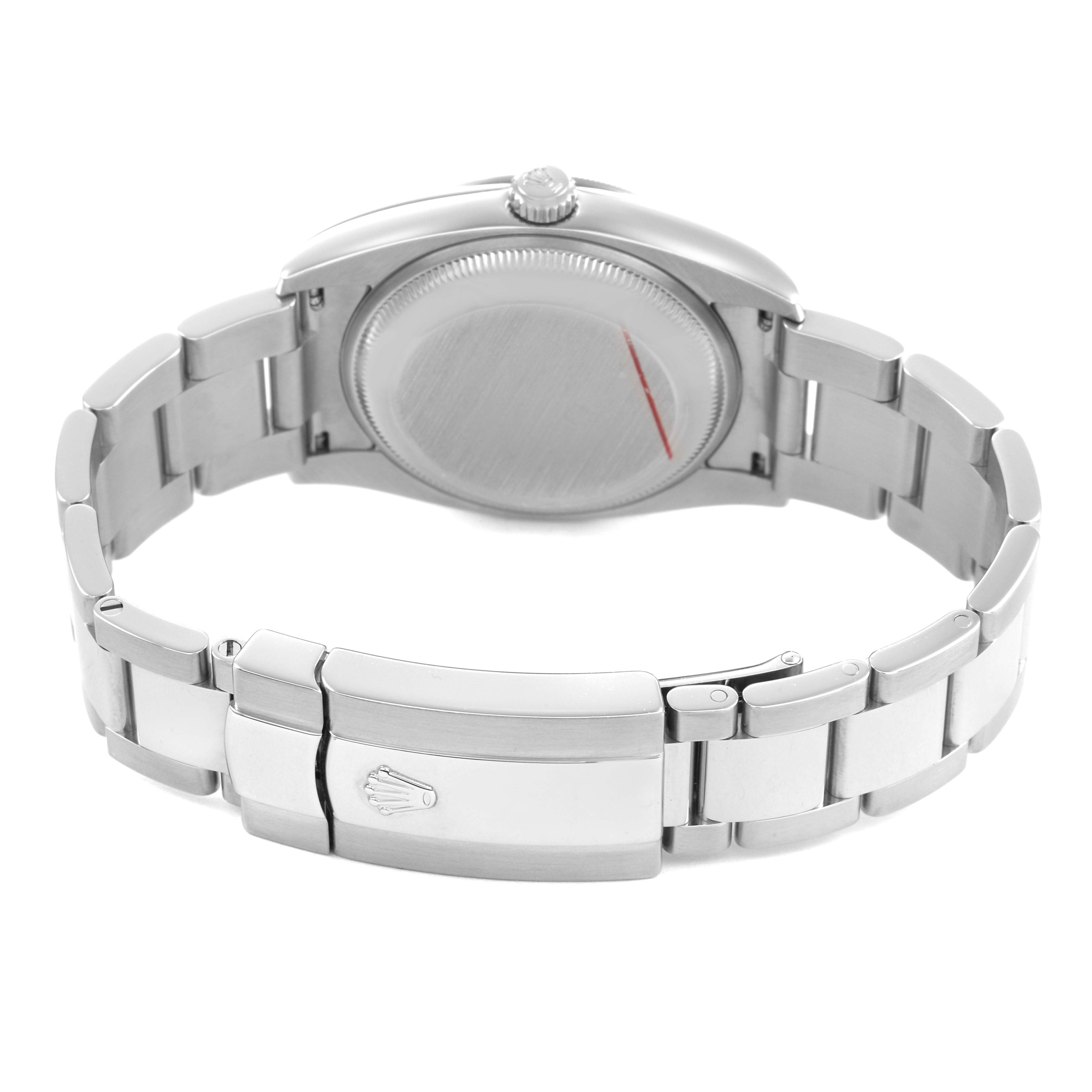 The image shows the back side of a Rolex Date 115210 Men's Stainless Steel Black Dial model watch, highlighting the case back and metal bracelet with the clasp.