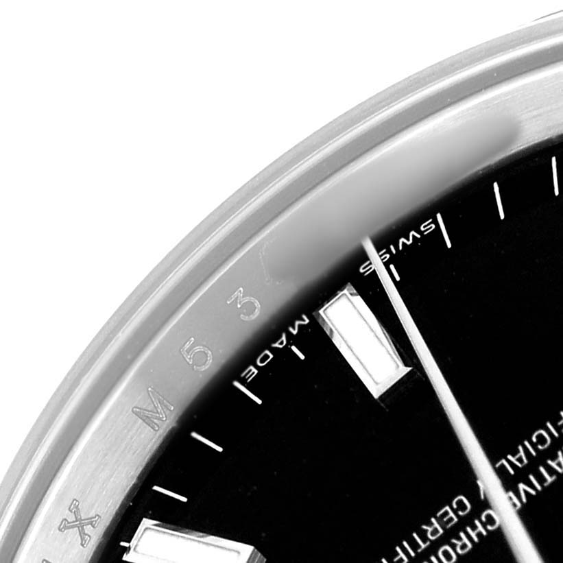 The image shows a close-up of the bezel and dial edge of a Rolex Date 115210 Men's Stainless Steel Black Dial watch, featuring the "Swiss Made" text.