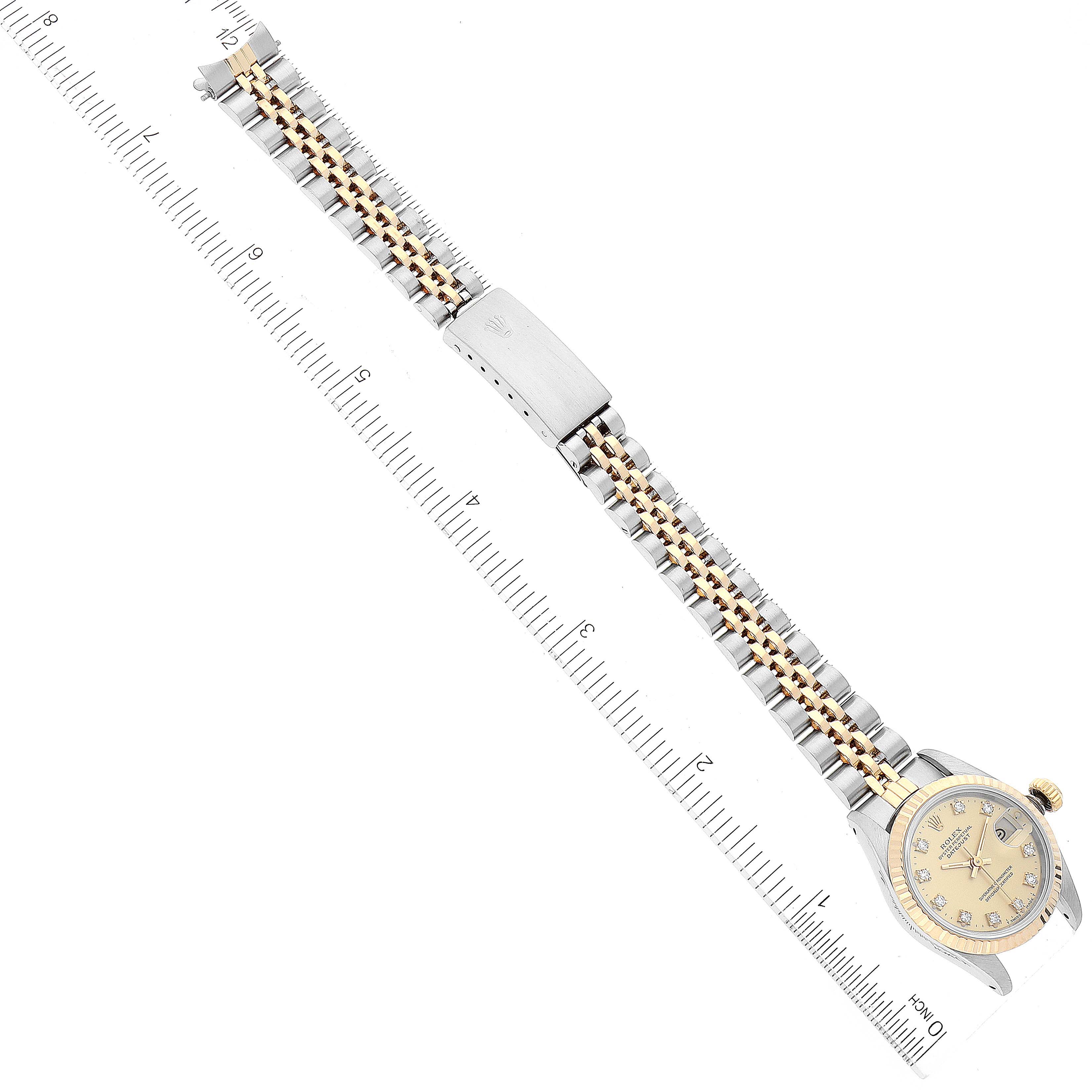 The image shows a top-down view of a Rolex Datejust 69173 Women's Steel and Gold (two tone) Champagne Dial 69173 Women's Steel and Gold (two tone) Champagne Dial watch with its band extended next to a ruler for scale.