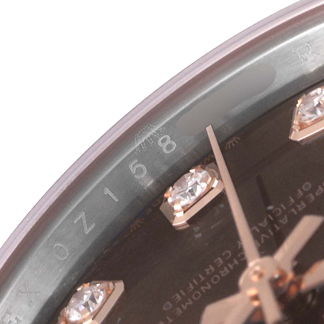 The image shows a close-up of the dial and hour markers of a Rolex Datejust 279381 Women's Steel and Gold (two tone) Brown Dial 279381 Women's Steel and Gold (two tone) Brown Dial watch, focusing on the serial number and diamond markers.