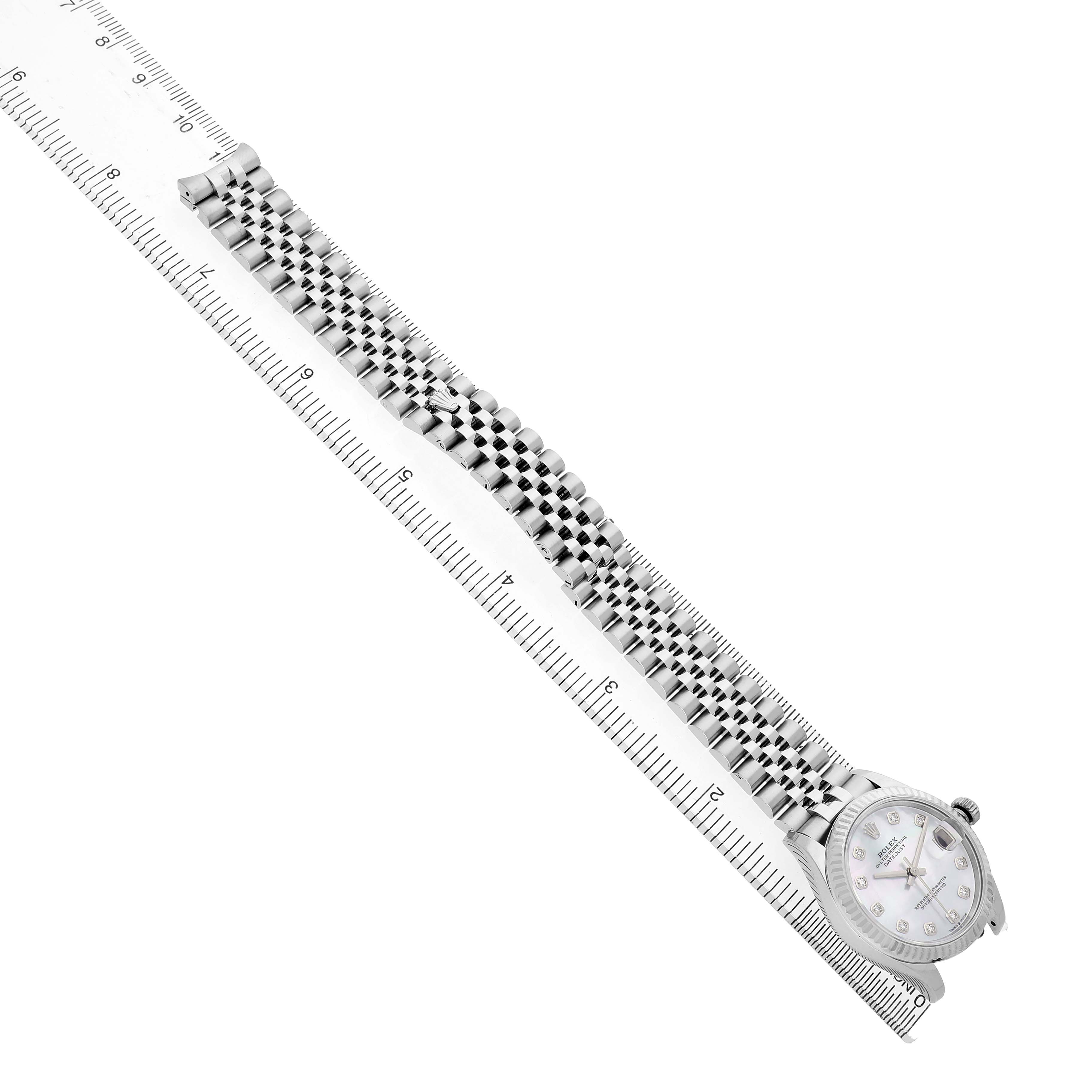 The Rolex Mid-Size 278274 Women's Steel and Gold (two tone) Mother of Pearl Dial watch is shown at an angled top view, highlighting the face, bezel, and bracelet beside a measuring ruler.