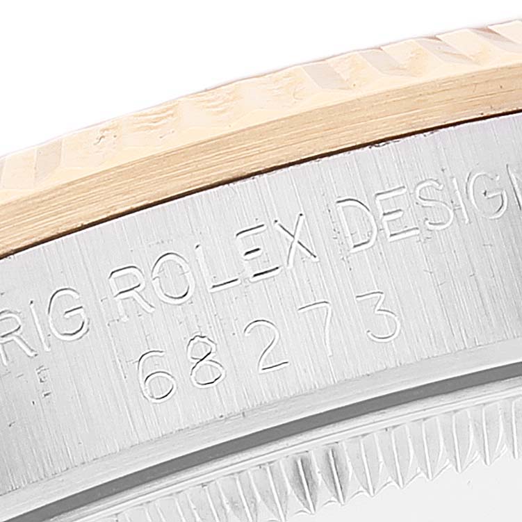 The image shows an angled close-up of the bezel and engraved case of a mid-size Rolex watch, model number 68273.