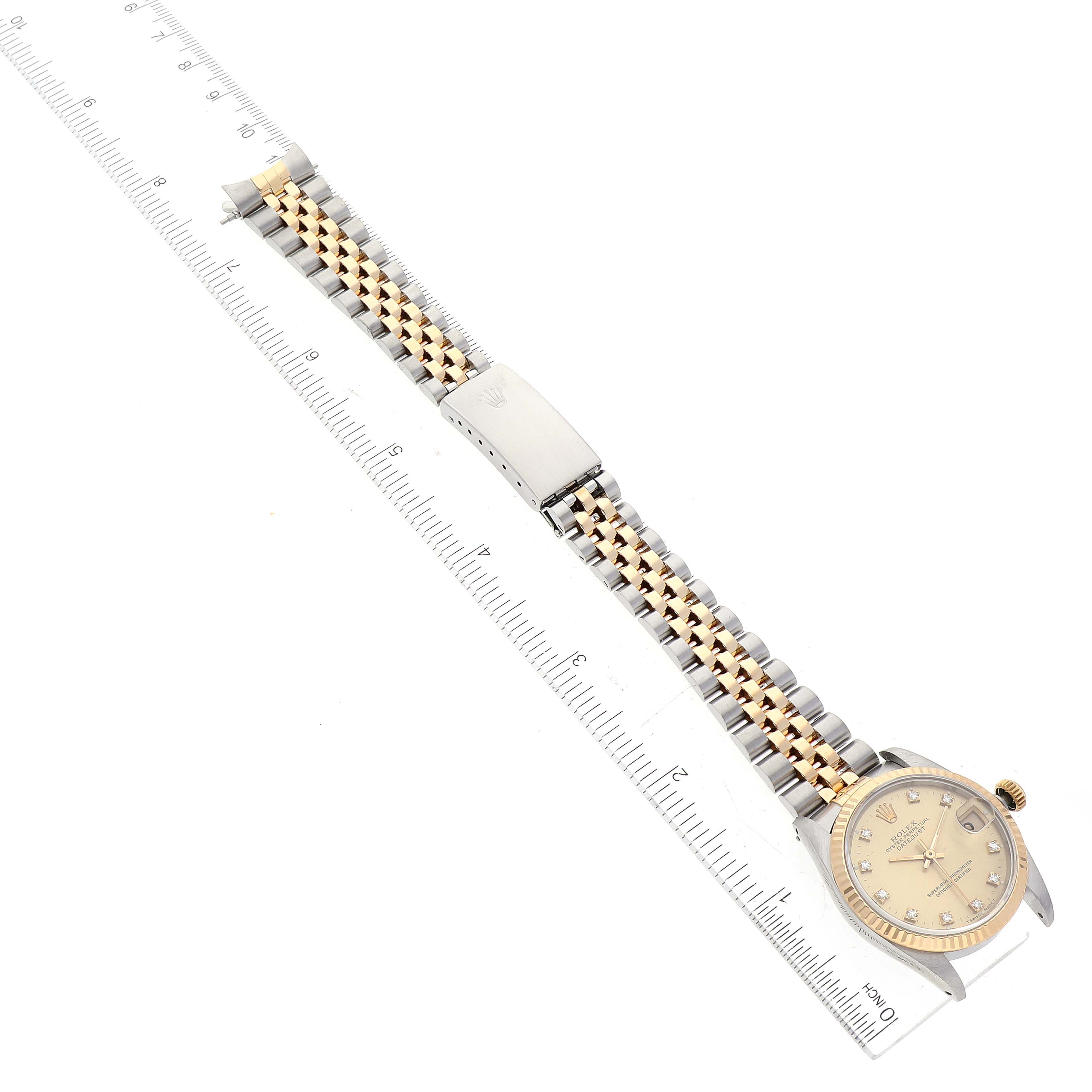 The image shows a top-down view of a Rolex Mid-Size 68273 Women's Steel and Gold (two tone) Champagne Dial 68273 Women's Steel and Gold (two tone) Champagne Dial model watch with a two-tone bracelet and a ruler for scale.