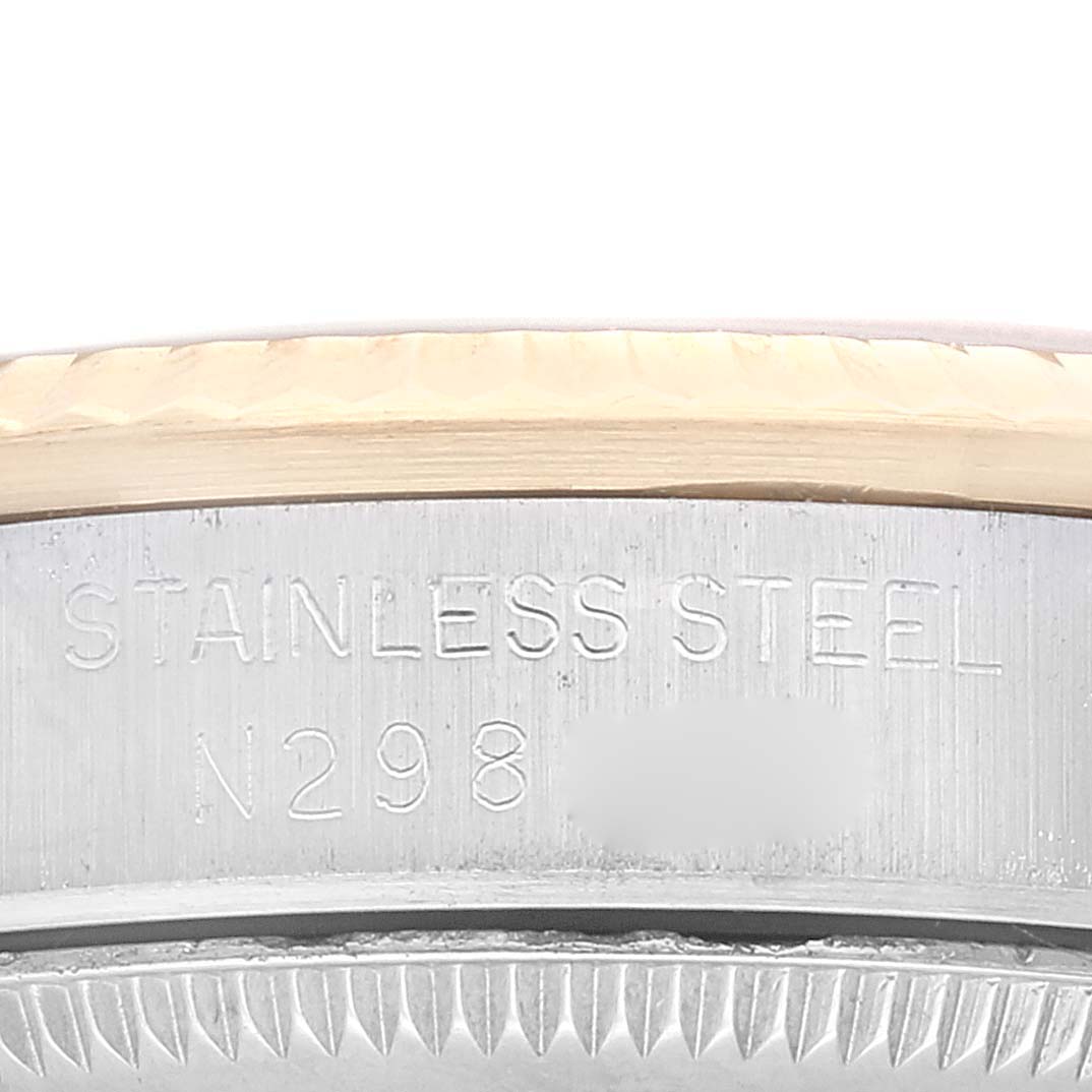 The image shows a close-up of the side of a stainless steel Rolex Mid-Size 68273 Women's Steel and Gold (two tone) Champagne Dial 68273 Women's Steel and Gold (two tone) Champagne Dial model watch with engraved text.