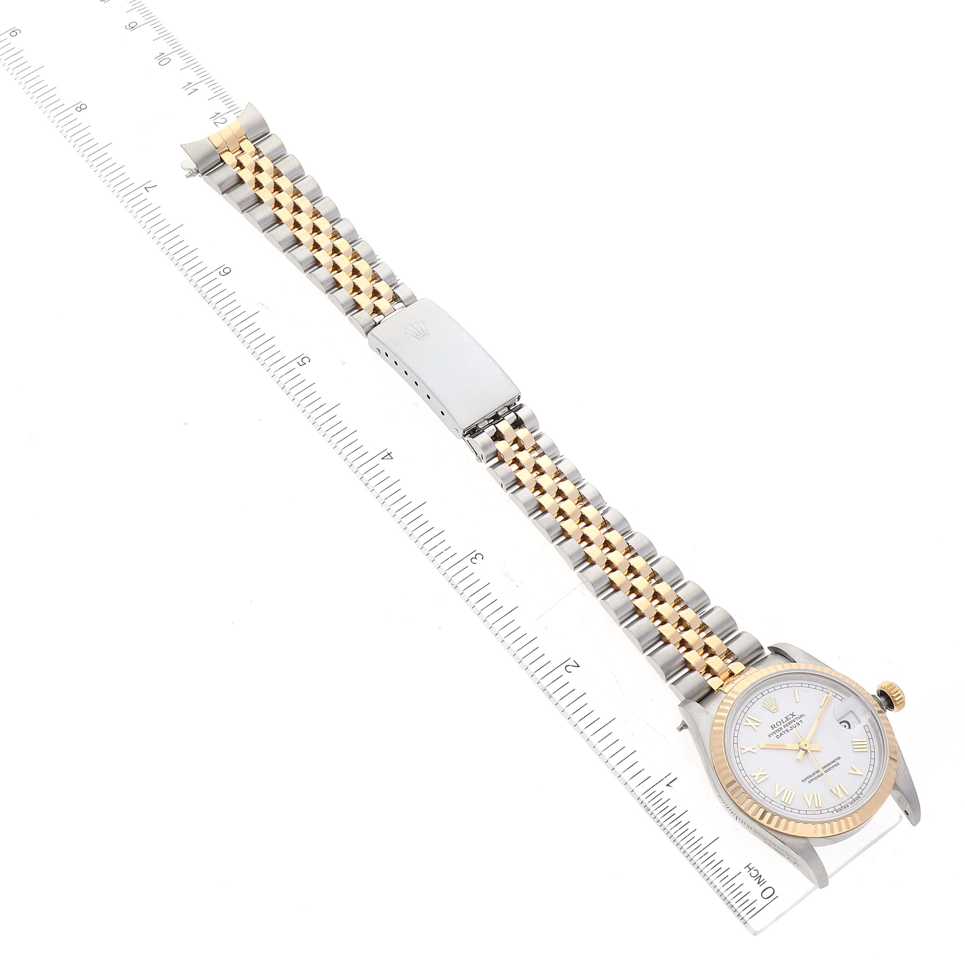 The image shows a Mid-Size Rolex watch at a top-down angle with the face, band, and clasp visible alongside a ruler.