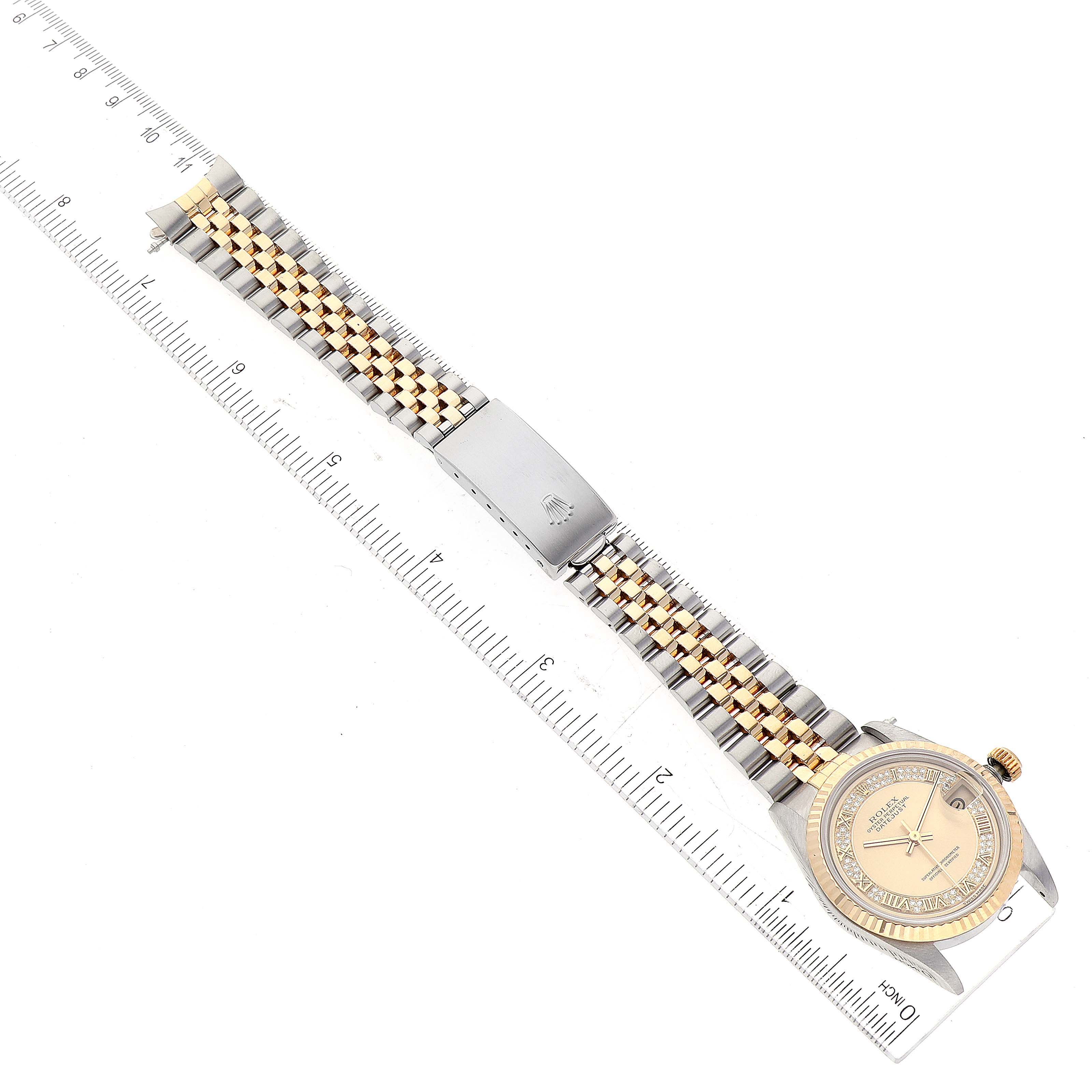 The image shows a top view of a Rolex Mid-Size 68273 Women's Steel and Gold (two tone) Champagne Dial 68273 Women's Steel and Gold (two tone) Champagne Dial model watch, displaying its face, band, and clasp against a ruler for scale.