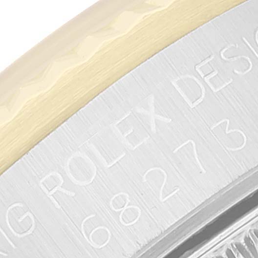 The image shows a close-up of the bezel and case of a Mid-Size Rolex watch, focusing on the engraved serial number and "Rolex Design" text.