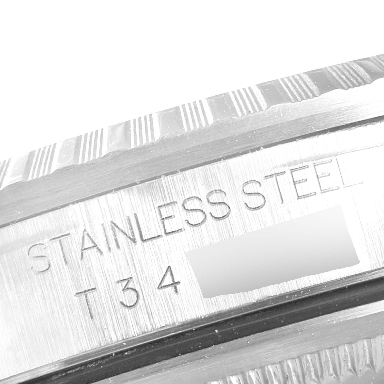The image shows an engraved part of the case side of a Rolex Datejust 16220 Men's Stainless Steel Silver Dial 16220 Men's Stainless Steel Silver Dial watch indicating "STAINLESS STEEL" and other details.