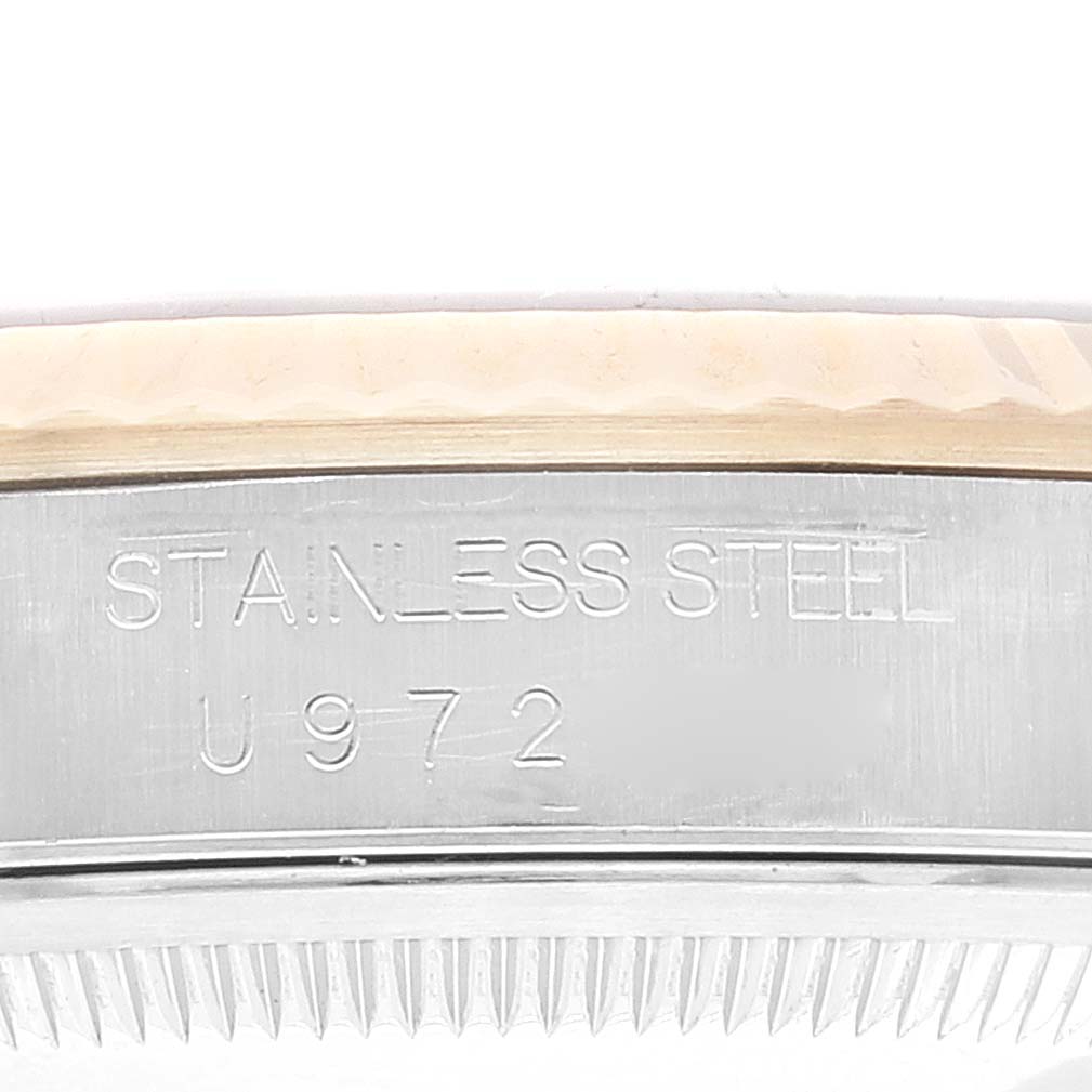 This image shows a close-up angled view of the Rolex Datejust 16233 Men's Steel and Gold (two tone)  16233 Men's Steel and Gold (two tone) 's case side engraving stating "STAINLESS STEEL" and "U972" with a portion of the bezel visible.