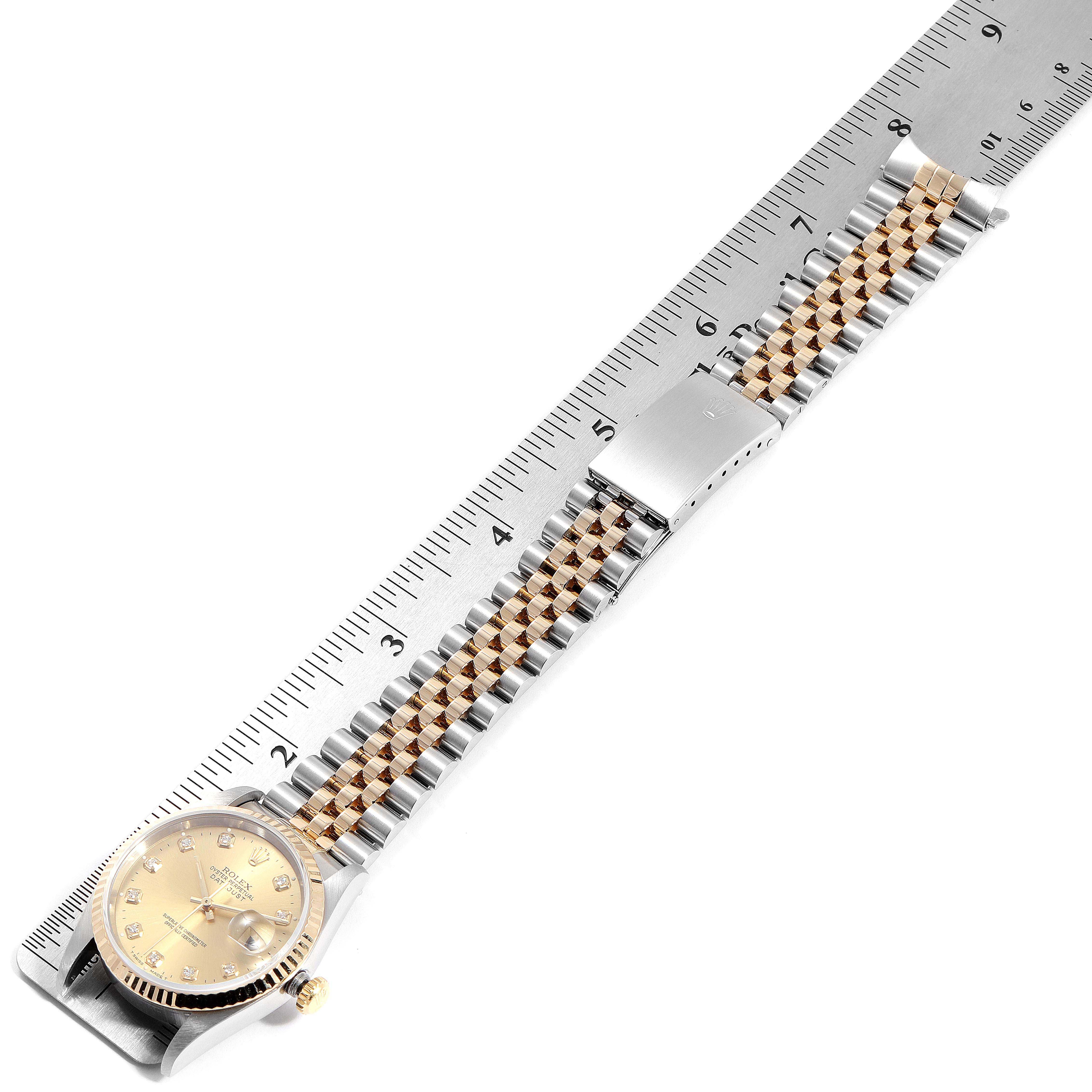 The image shows a Rolex Datejust 16233 Men
s Steel and Gold (two tone) Champagne Dial 16233 Men
s Steel and Gold (two tone) Champagne Dial watch laid flat with its two-tone bracelet measured against a ruler.