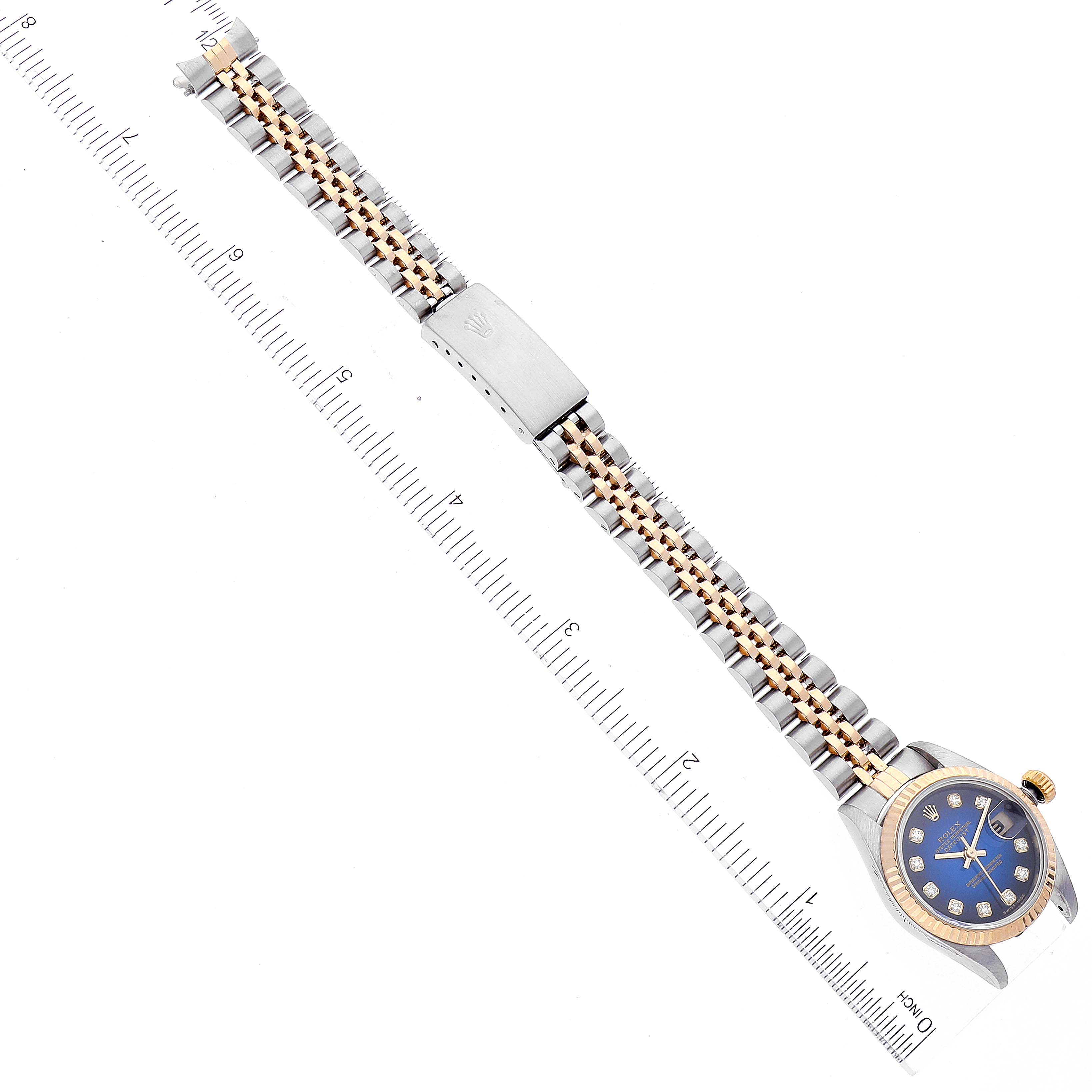 The image shows a Rolex Datejust 79173 Women
s Steel and Gold (two tone) Blue Dial 79173 Women
s Steel and Gold (two tone) Blue Dial watch laid flat, displaying the full strap, clasp, and face, measured against a ruler.