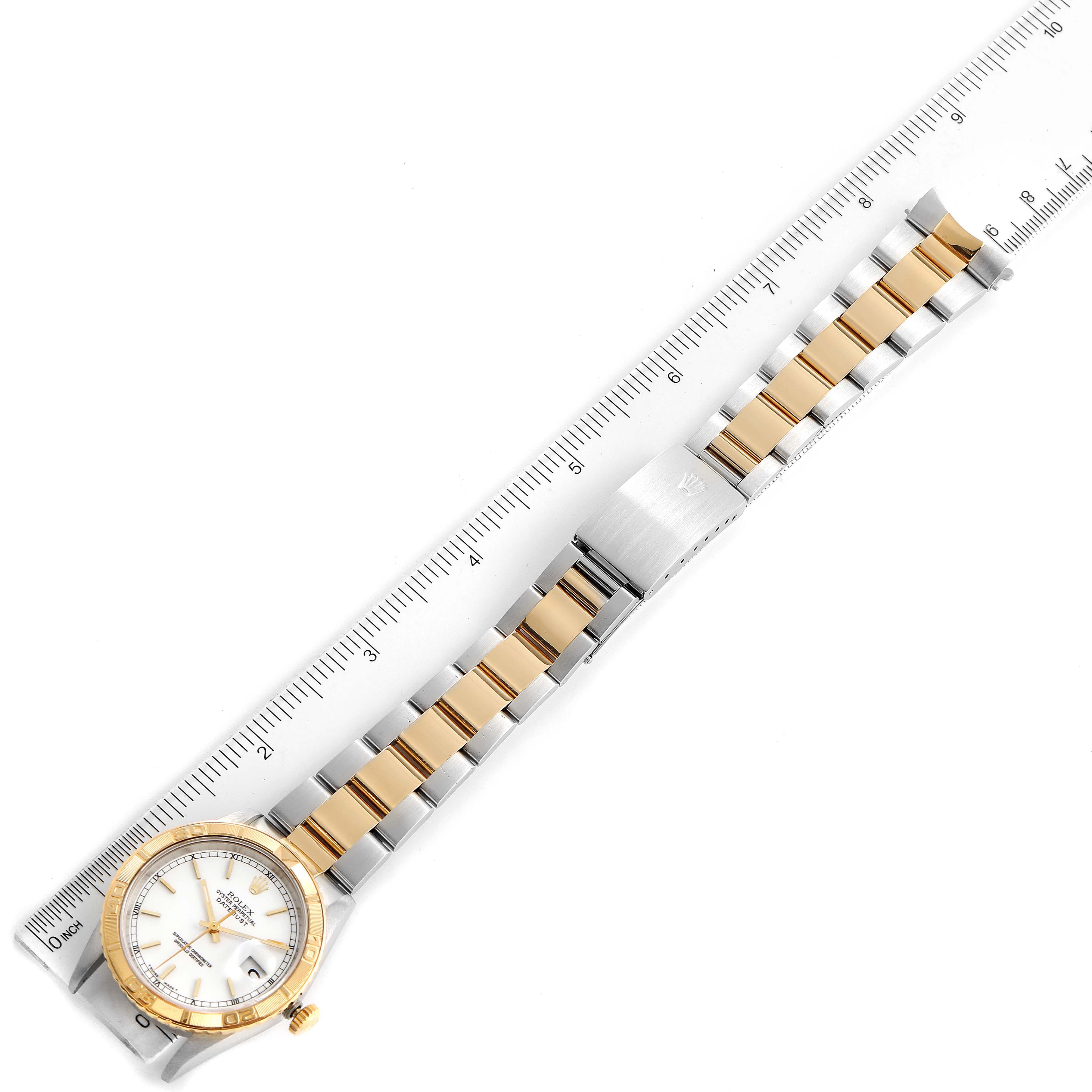 The Rolex Turn-o-Graph 16263 Men's Steel and Gold (two tone) White Dial 16263 Men's Steel and Gold (two tone) White Dial watch is shown from a top-down angle, highlighting the entire band, clasp, and watch face next to a ruler for scale.