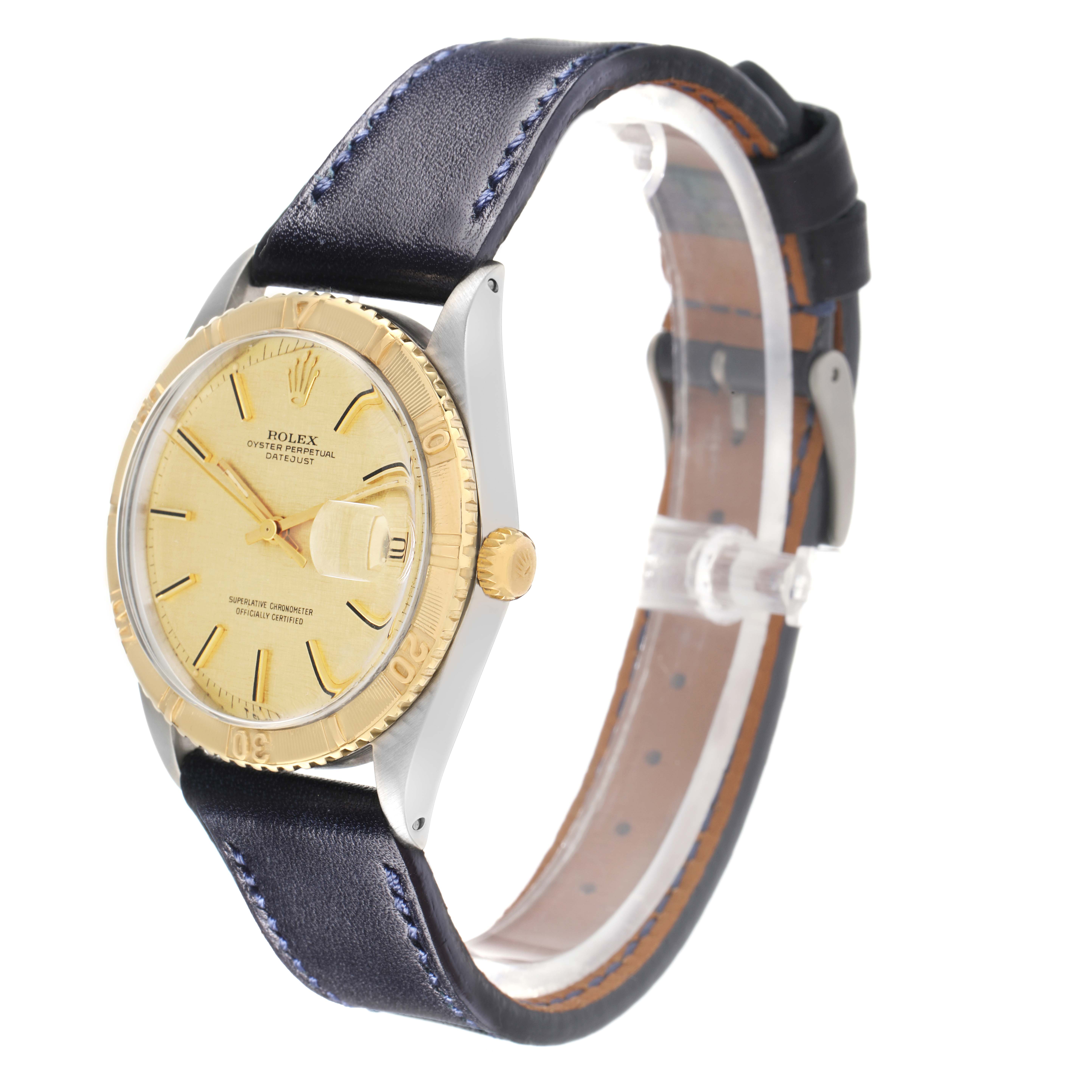 The Rolex Turn-o-Graph 1625 Men
s Steel and Gold (two tone) Champagne Dial watch is shown at an angle highlighting the face, bezel, and part of the leather strap.