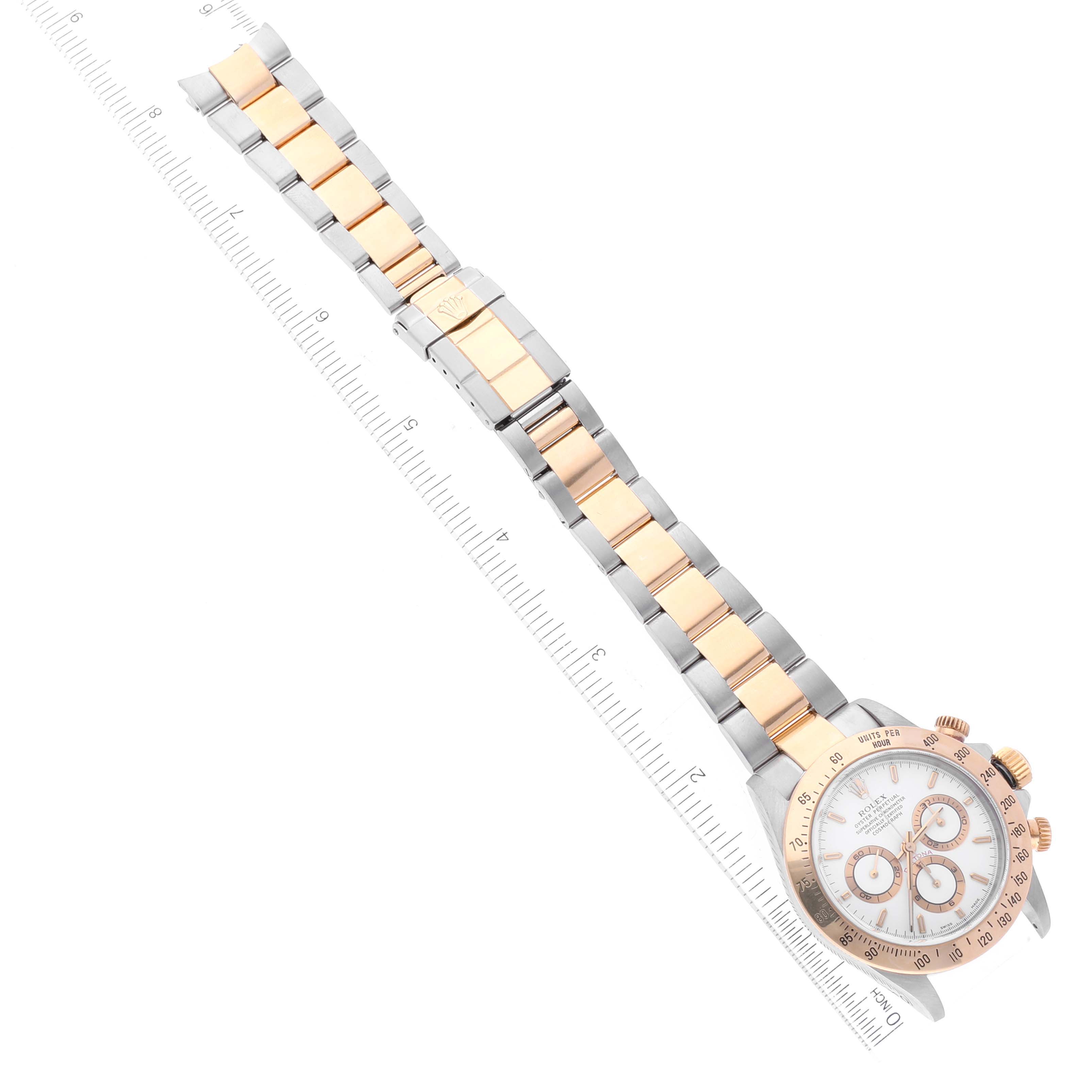 This image shows a Rolex Daytona 16523 Men
s Steel and Gold (two tone) White Dial 16523 Men
s Steel and Gold (two tone) White Dial watch at an angled top-down view, with an extended two-tone bracelet and a ruler for scale.
