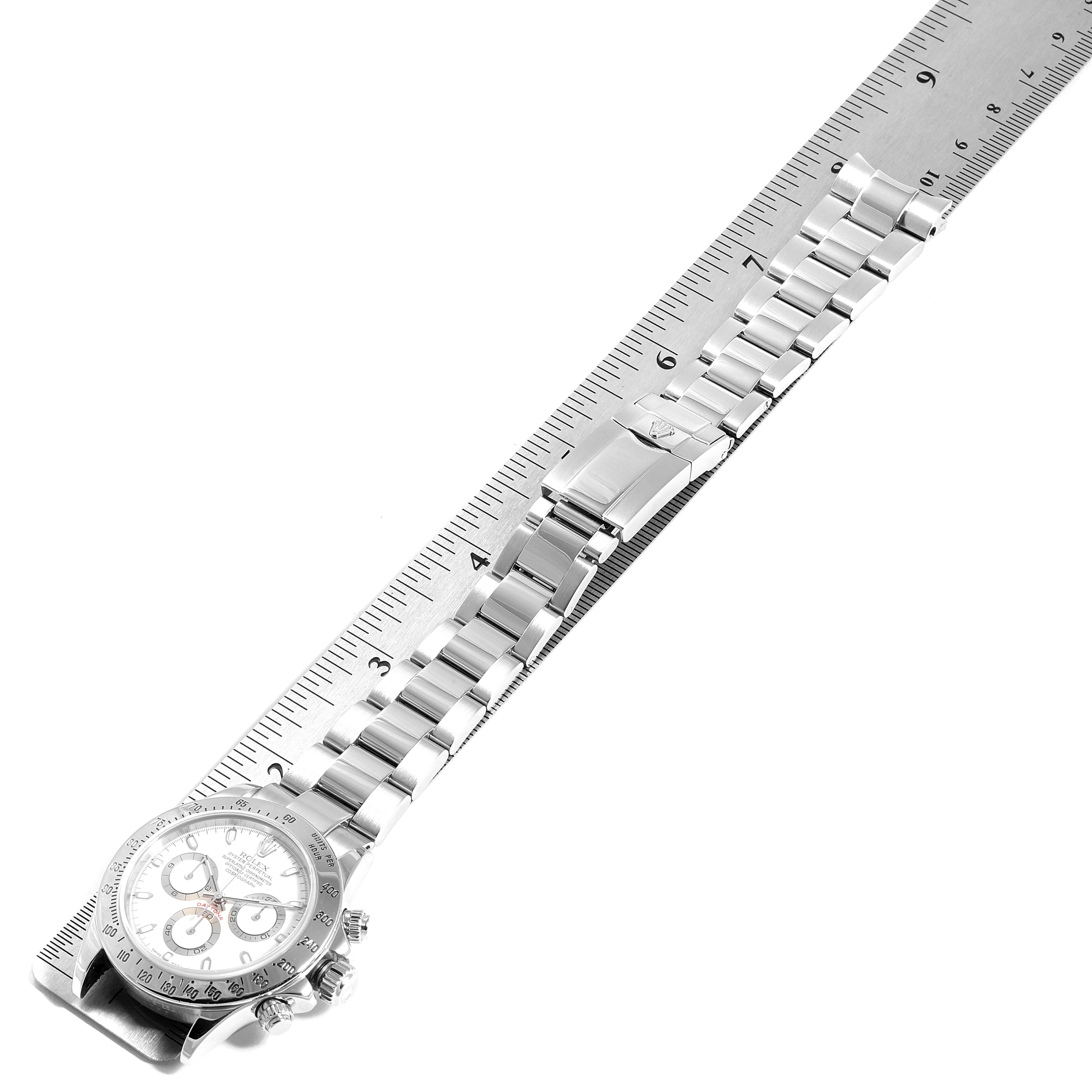 The image shows the Rolex Daytona 116520 Men's Stainless Steel White Dial 116520 Men's Stainless Steel White Dial watch laid flat next to a ruler, highlighting the bracelet and clasp from an overhead angle.