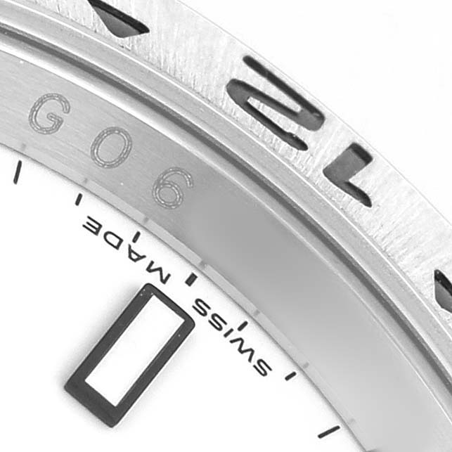 The image shows a close-up of the Rolex Explorer 16570 Men's Stainless Steel White Dial's bezel and dial, focusing on engraved details and partial numerals.