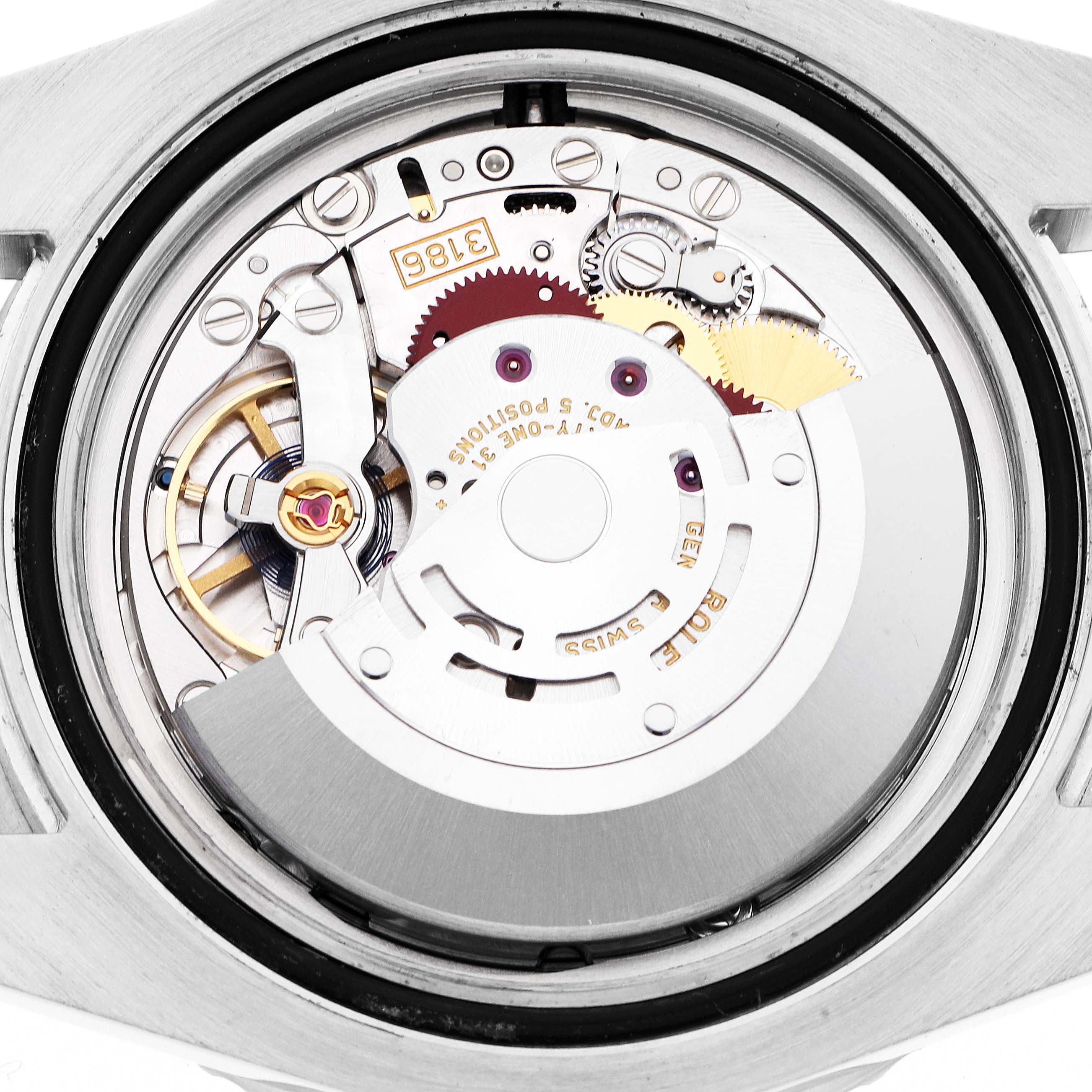 The image shows the movement of a Rolex GMT-Master 116710 Men
s Stainless Steel Black Dial watch from a top-down angle, highlighting gears and components.