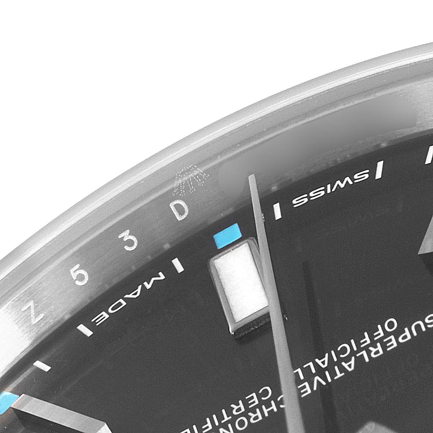 This image shows a close-up of the dial and outer ring on a Rolex Oyster Perpetual 114300 Men's Stainless Steel Silver Dial 114300 Men's Stainless Steel Silver Dial watch, highlighting the markings and hands.