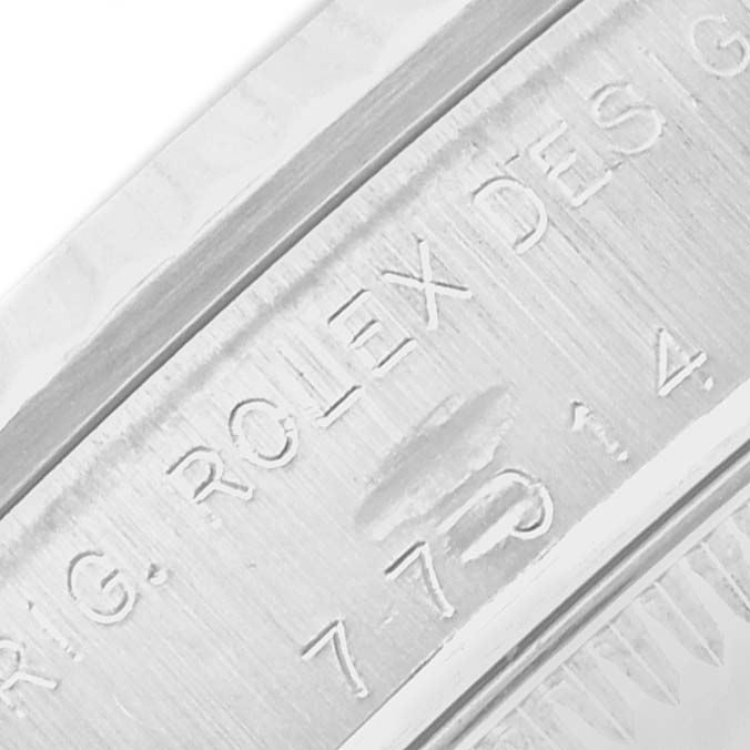 The image shows a close-up of the engraved case side of a Rolex Oyster Perpetual 77014 Women
s Stainless Steel Black Dial watch.