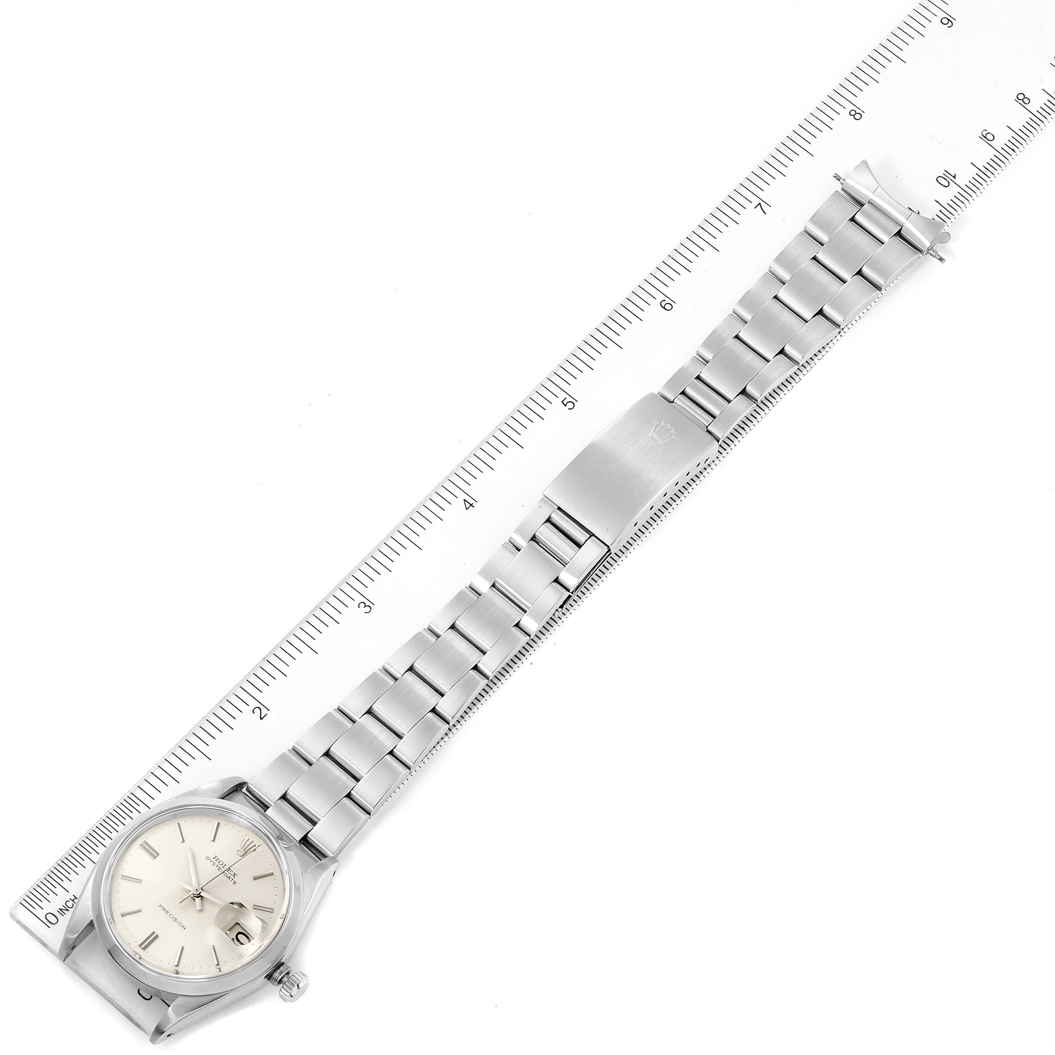 The Rolex Vintage Collection 6694 Men's Stainless Steel Silver Dial 6694 Men's Stainless Steel Silver Dial watch is shown from an above angle, displaying the watch face, bracelet, and clasp alongside a ruler for scale.