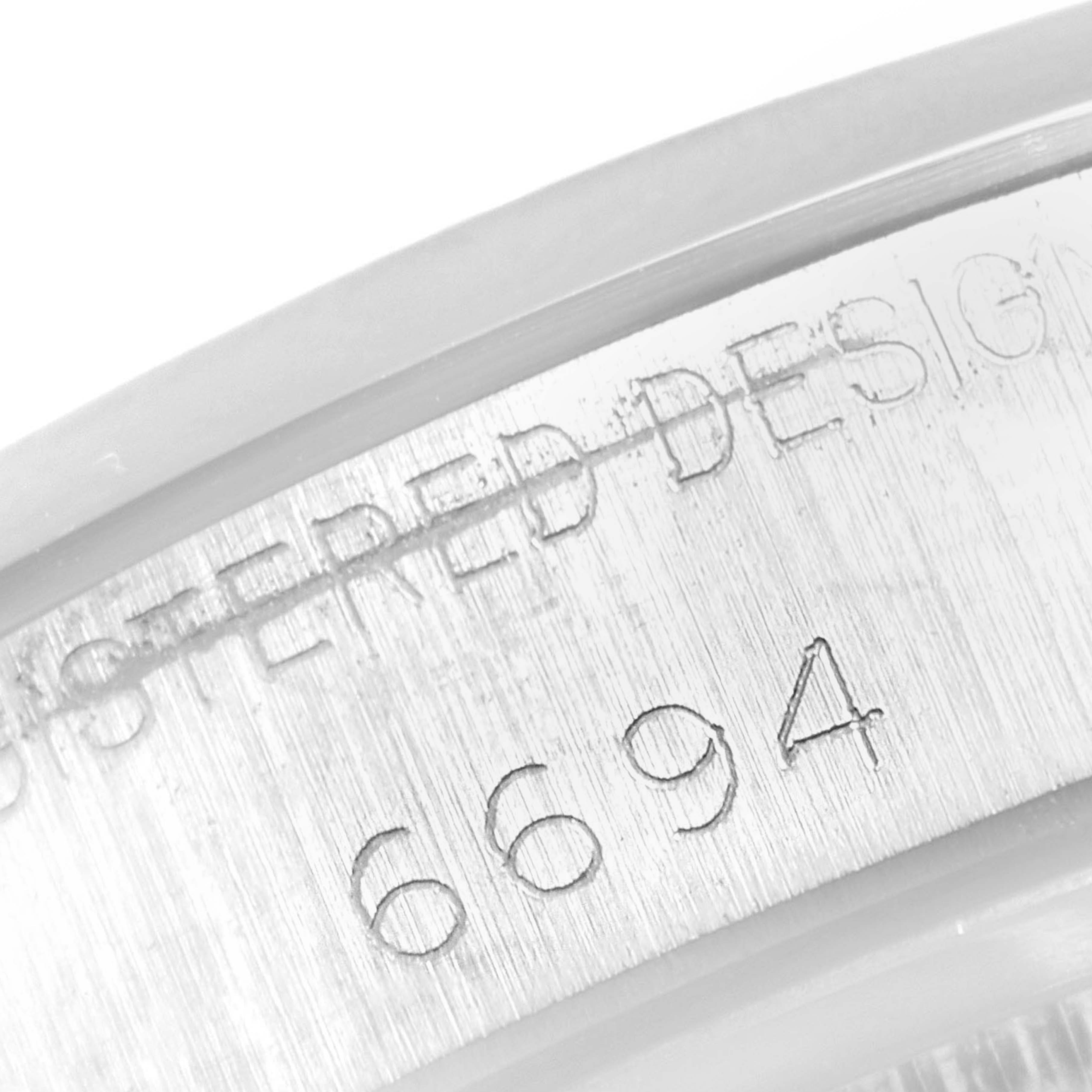 The image shows a close-up angle of the serial number engraving "6694" on the Vintage Collection Rolex watch.