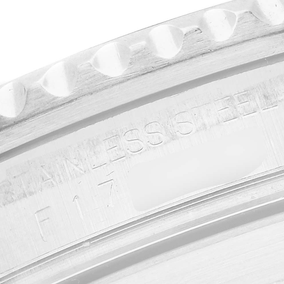 The image shows a close-up of the side of a Rolex Submariner 16610 Men
s Stainless Steel Black Dial watch, focusing on the stainless steel case with engraved text.