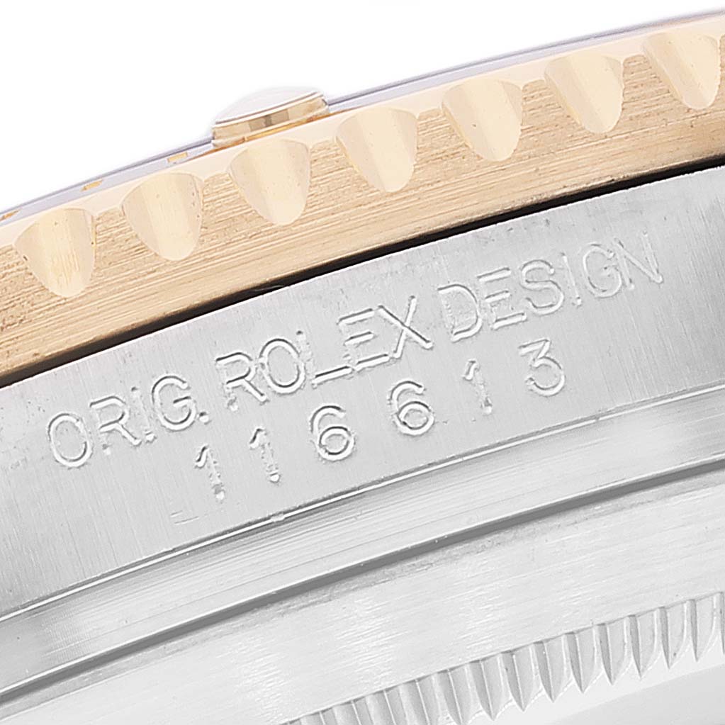This close-up image shows the engraved model number and the edge of the bezel on a Rolex Submariner 116613 Men's Steel and Gold (two tone) Black Dial 116613 Men's Steel and Gold (two tone) Black Dial watch.