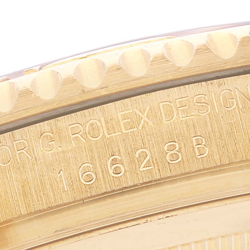 The image shows a close-up of the engraved bezel edge and case side of a Rolex Yacht-Master 16628 Men's Yellow Gold White Dial watch.