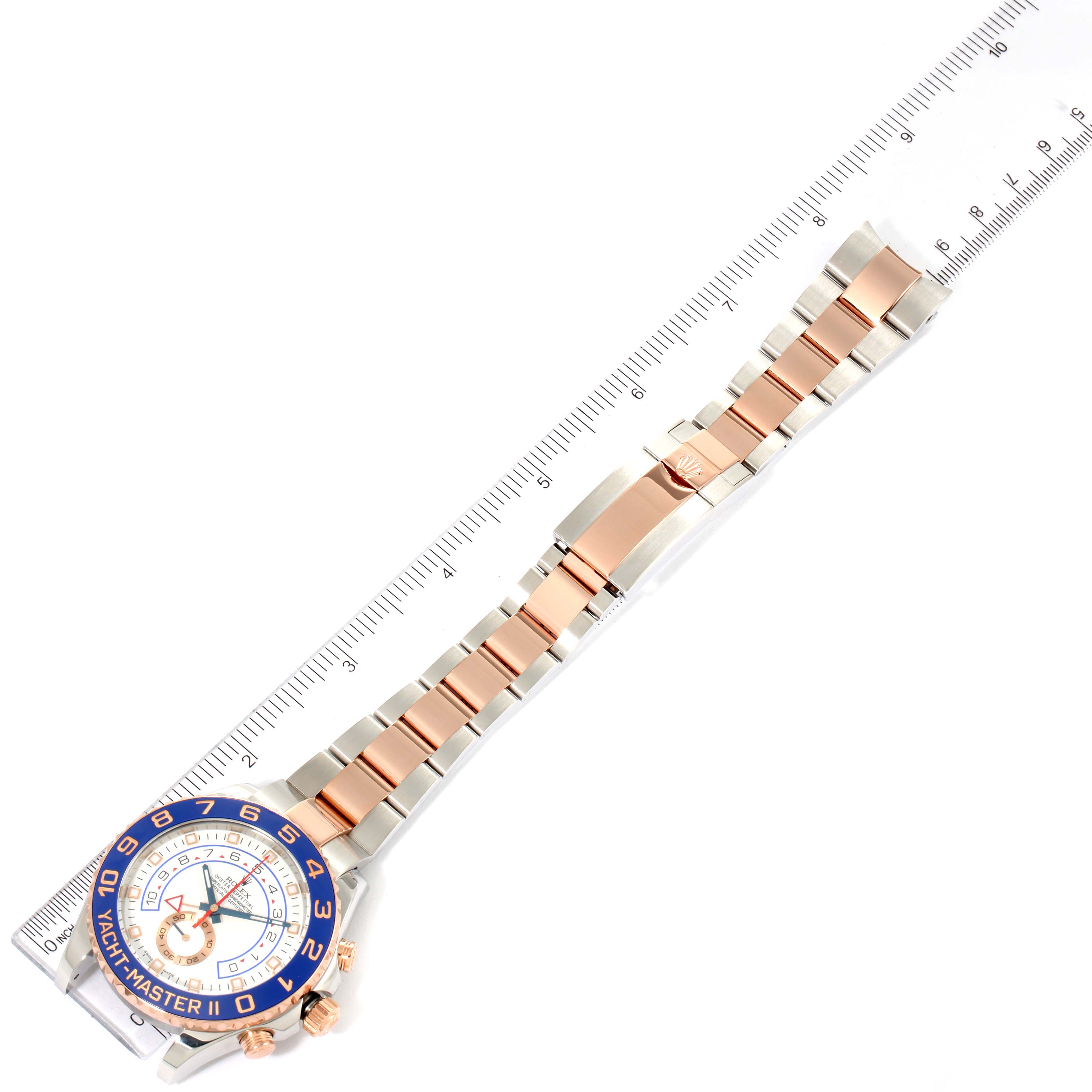 The Rolex Yacht-Master 116681 Men
s Steel and Gold (two tone) White Dial 116681 Men
s Steel and Gold (two tone) White Dial watch is shown from above, displaying the face, bezel, crown, and the full bracelet laid alongside a ruler.