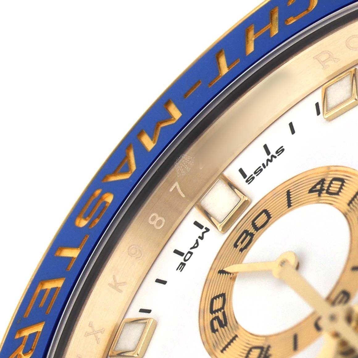The image shows a close-up of the Rolex Yacht-Master 116688 Men's Yellow Gold White Dial's blue bezel and gold dial with partial indices.