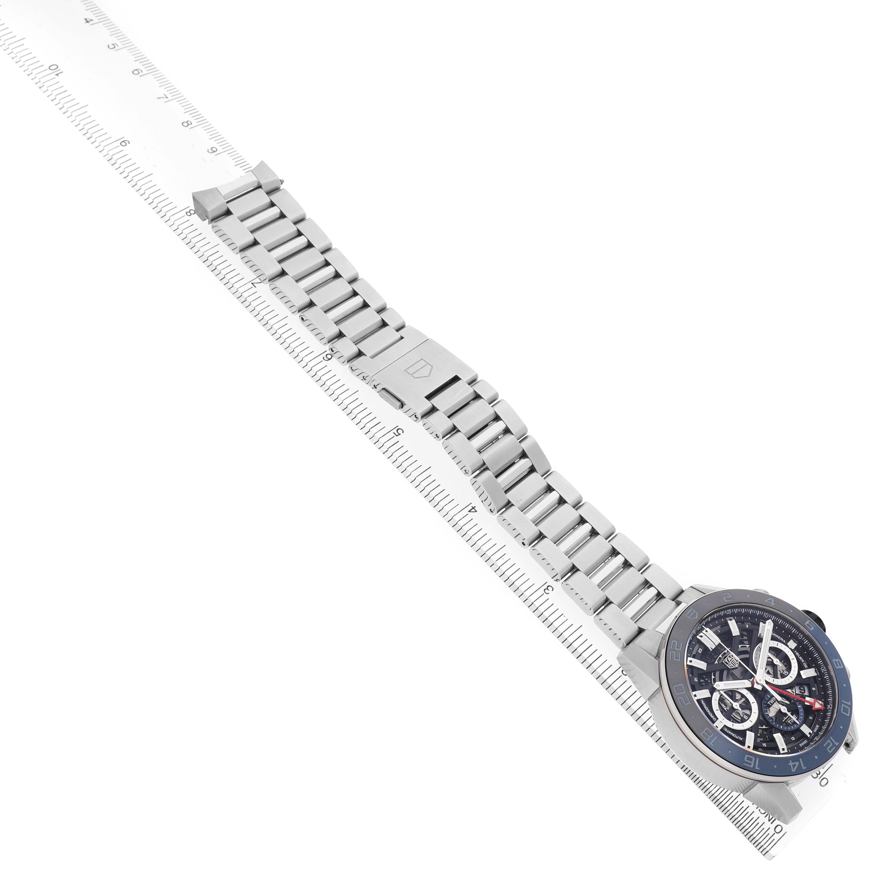 The Carrera by Tag Heuer is shown at an angled side view, displaying the face, bracelet, and clasp.