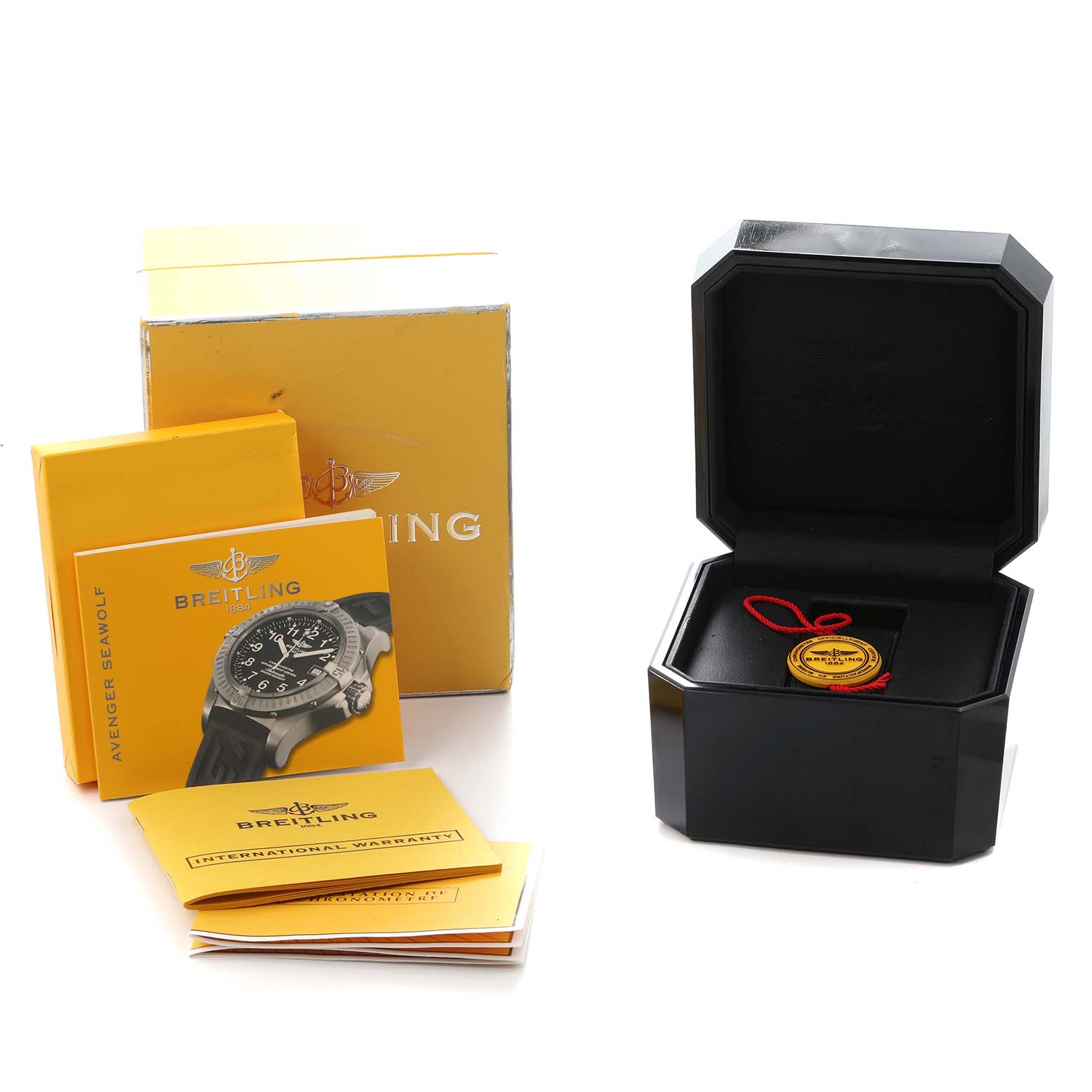 The image shows a Breitling Avenger E17370 Men
s Titanium Yellow Dial box, warranty cards, manuals, and a black watch case with a tag inside.