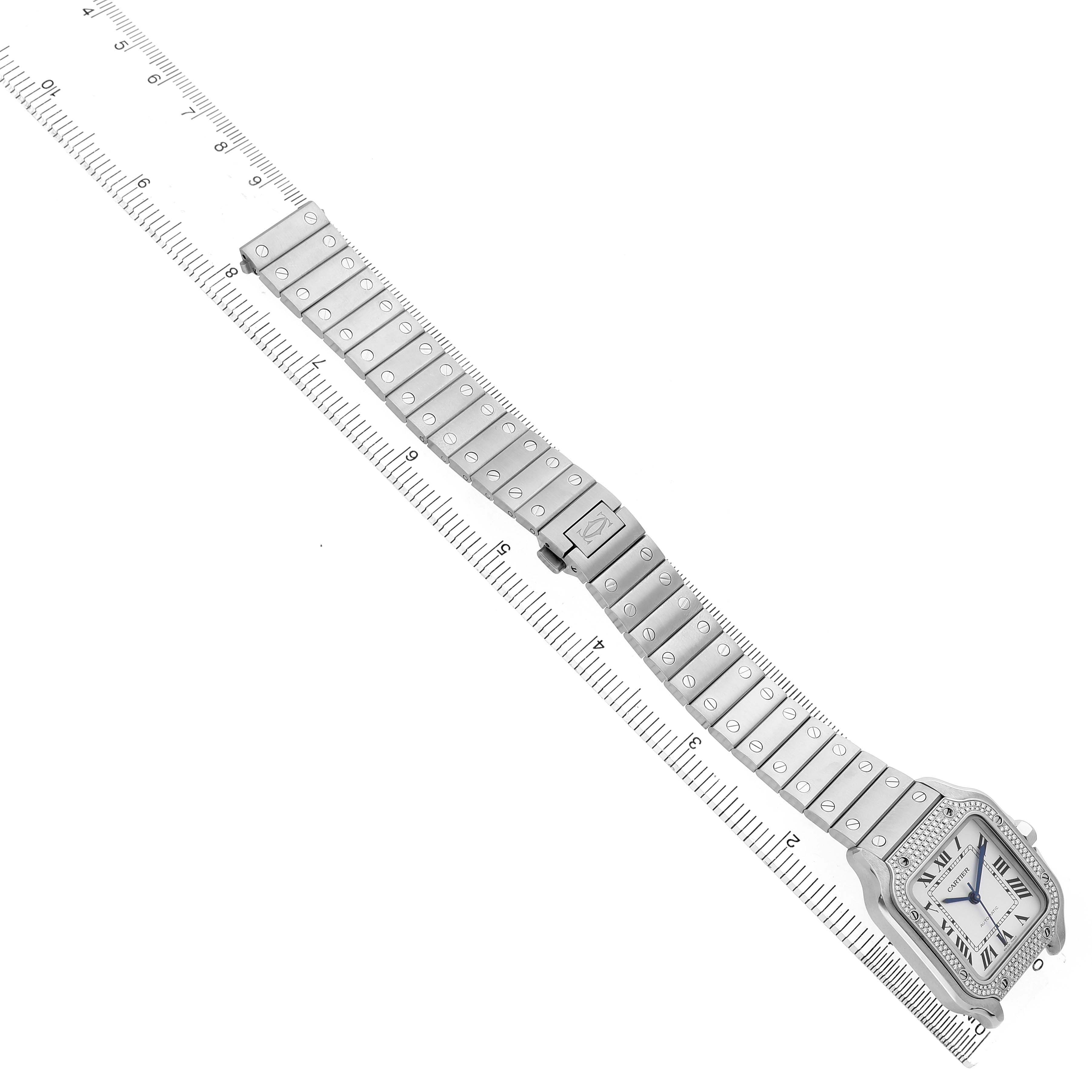 The Santos model by Cartier is shown from an angled top view, displaying the full watch and bracelet with ruler for scale.