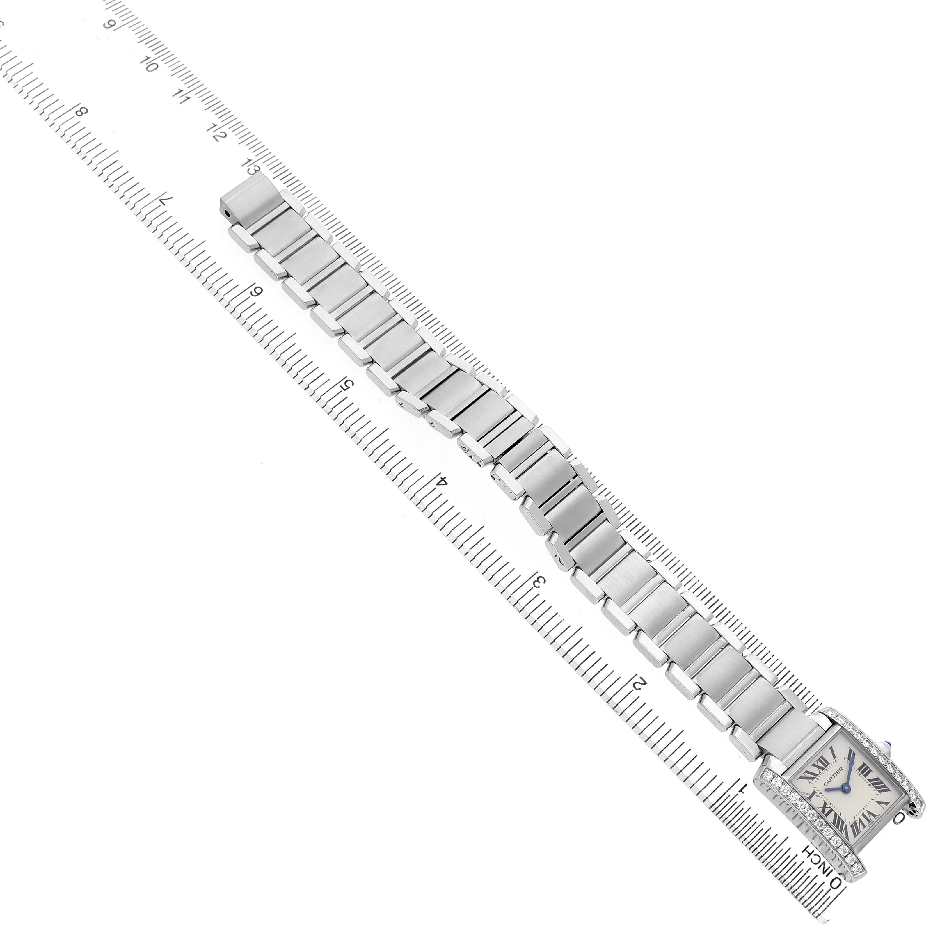The Cartier Tank Française watch is displayed flat, showing the face and full bracelet-length aligned with a ruler.