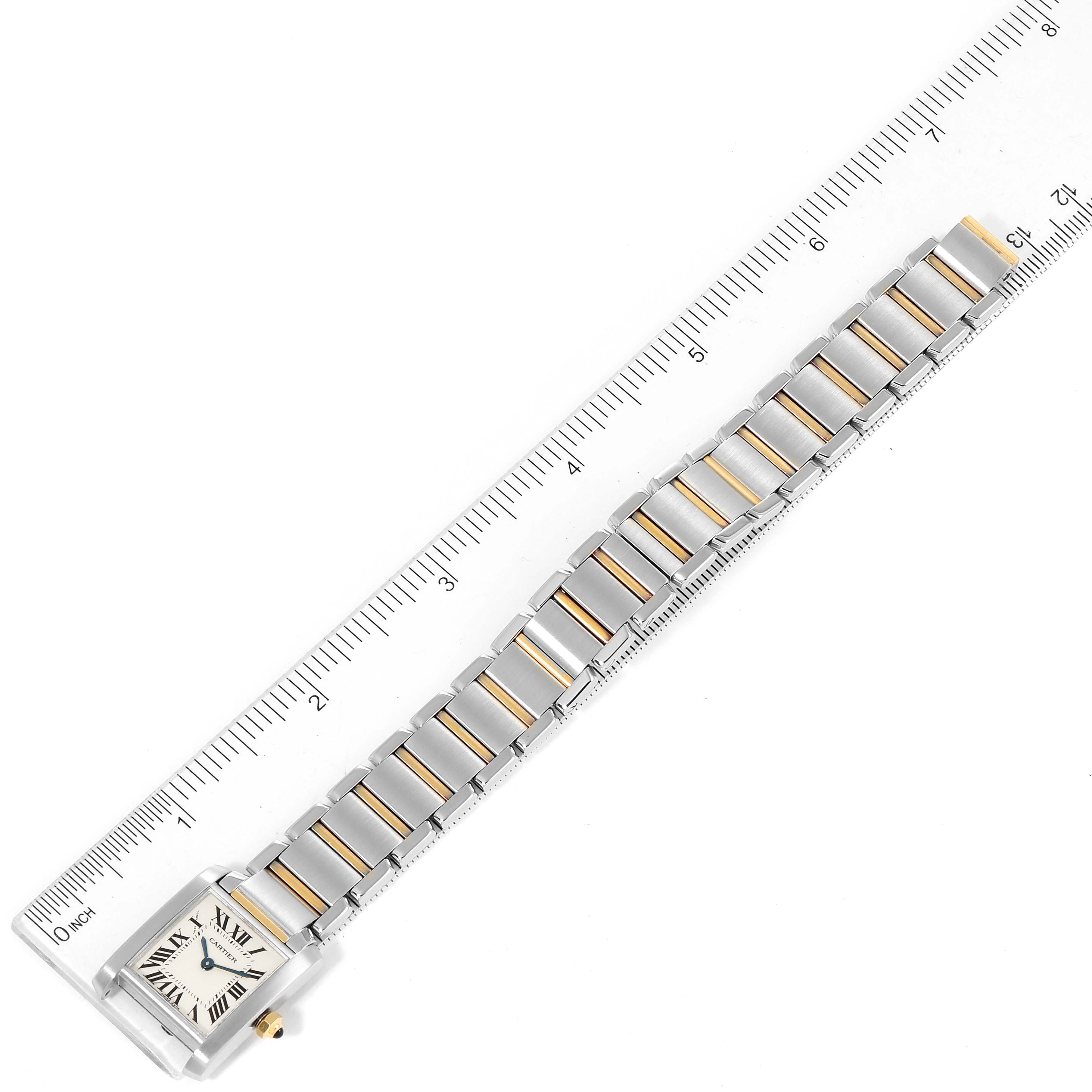 The image shows a Tank Française model by Cartier, focusing on its bracelet and face, laid alongside a ruler for measurement.