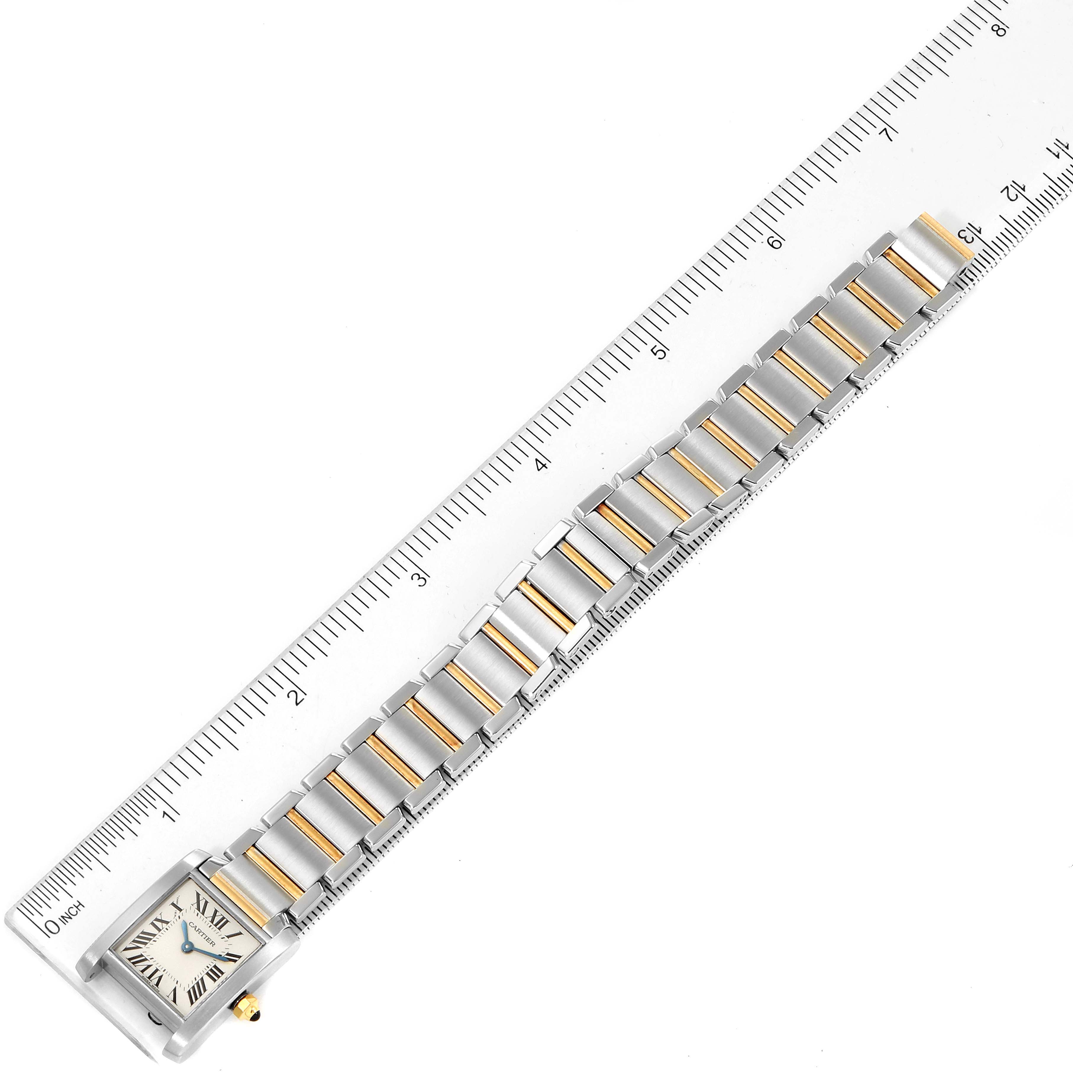 The image shows a top-down view of a Cartier Tank Francaise W51007Q4 Women's Steel and Gold (two tone) Silver Dial W51007Q4 Women's Steel and Gold (two tone) Silver Dial watch next to a ruler, showcasing its bracelet and face.