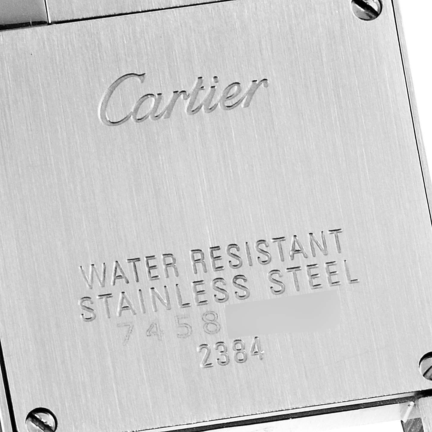 The image shows the back plate of a Cartier Tank Française watch, highlighting its engraving and stainless steel material.