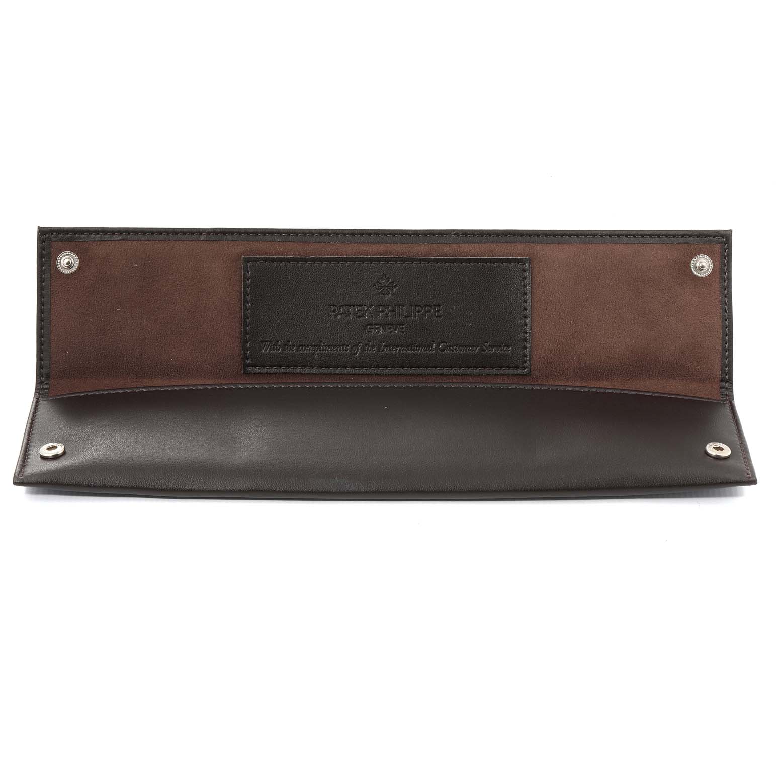A Patek Philippe watch pouch, laid flat, showing the interior with the brand’s embossed logo and snap closure buttons.