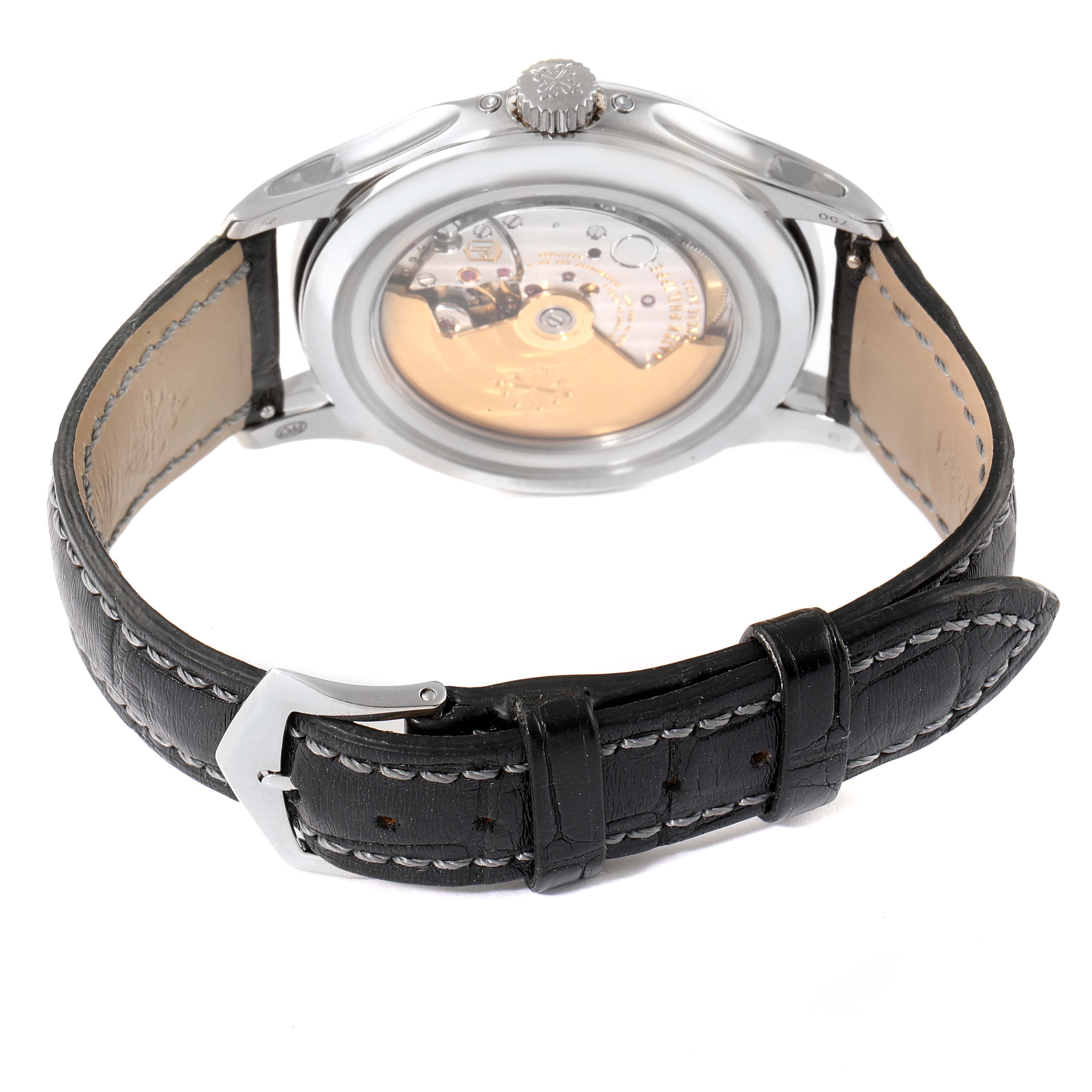 The image shows the back view of a Patek Philippe Complications 5205G - 010 Men's White Gold Grey Dial 5205G - 010 Men's White Gold Grey Dial watch, highlighting the movement and leather strap with stitching.