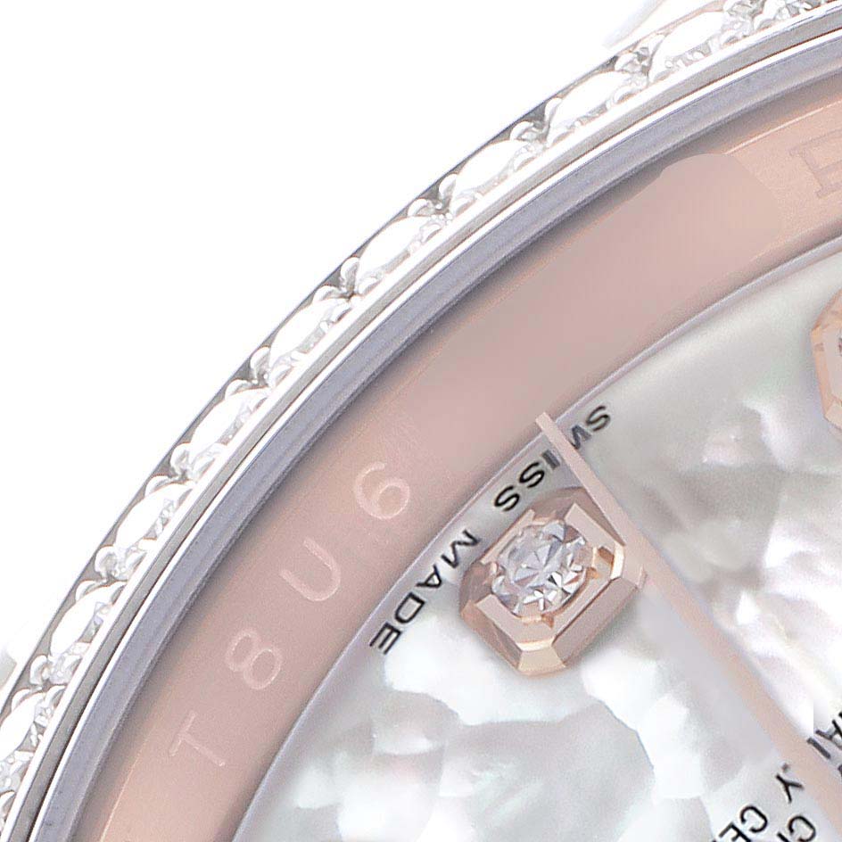 The image shows a close-up of the dial and bezel of a Rolex Datejust 116185 Men
s Rose Gold Mother of Pearl Dial, highlighting the diamond hour markers and textured edge.