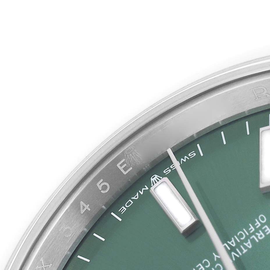 The image shows a close-up of the dial and bezel edge of a Rolex Datejust 126200 Men's Stainless Steel Green Dial watch, focusing on markers and "Swiss Made" text.