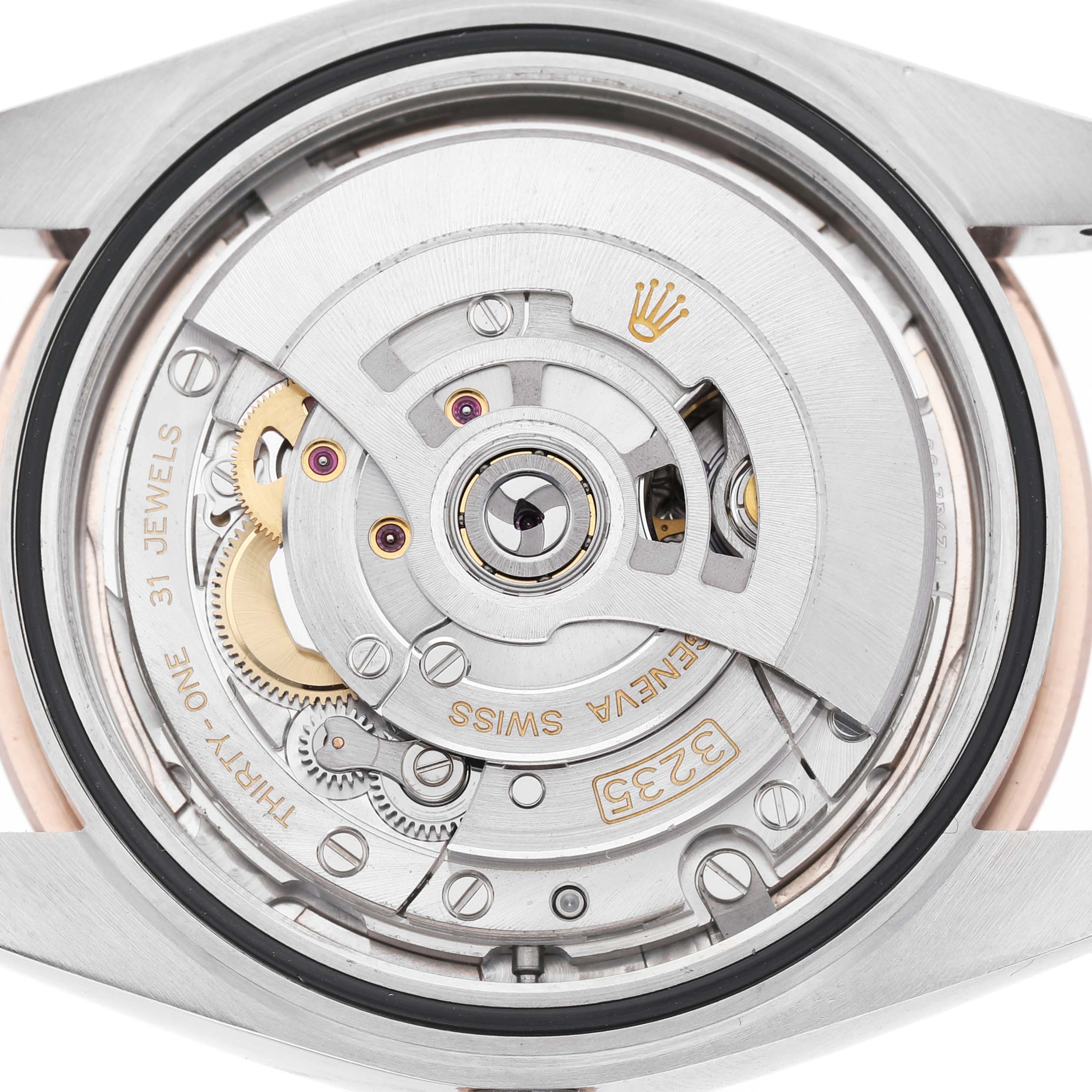 This image shows the case back and movement of a Rolex Datejust 126331 Men's Steel and Gold (two tone) Pink Dial, showcasing the rotor and intricate mechanical parts.
