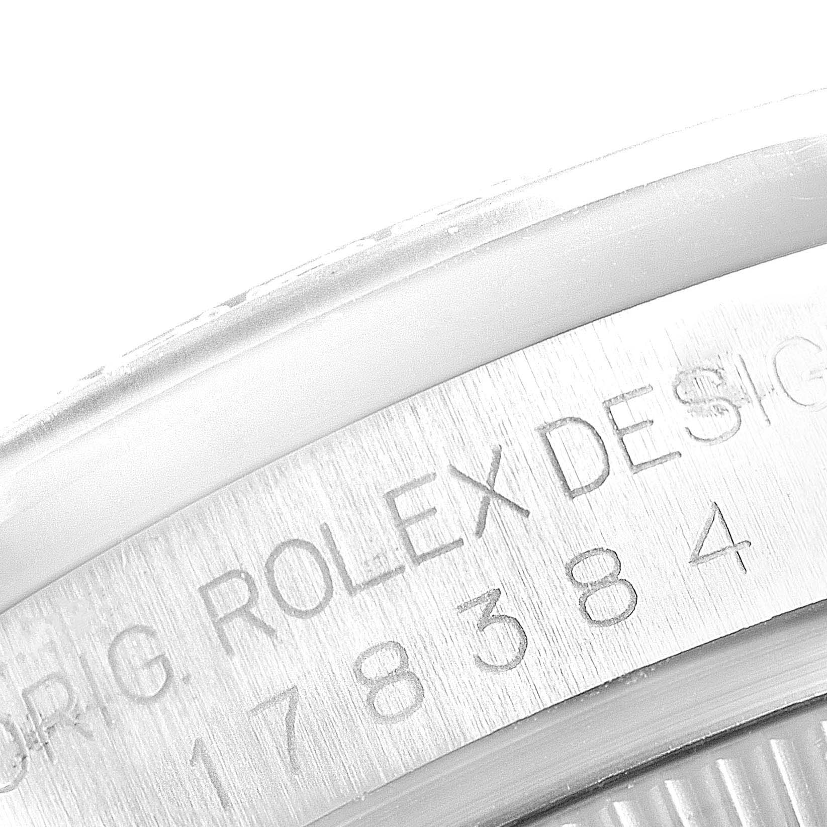This image shows a close-up of the engraved text "ORIG. ROLEX DESIGN" and a part of the serial number on a Mid-Size Rolex watch case back.