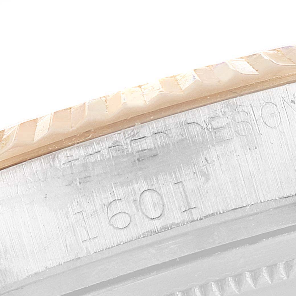 This image shows a close-up of the case and bezel of a Rolex Vintage Collection 1601 Men's Steel and Gold (two tone) Black Dial 1601 Men's Steel and Gold (two tone) Black Dial model, focusing on the etched serial number.
