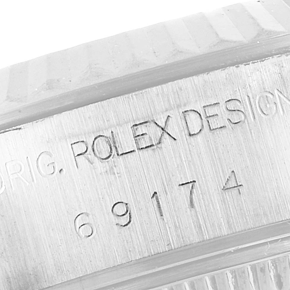 This image shows the engraved serial number and "Rolex Design" text on the case of a Rolex Datejust 69174 Women
s Stainless Steel Silver Dial 69174 Women
s Stainless Steel Silver Dial watch.