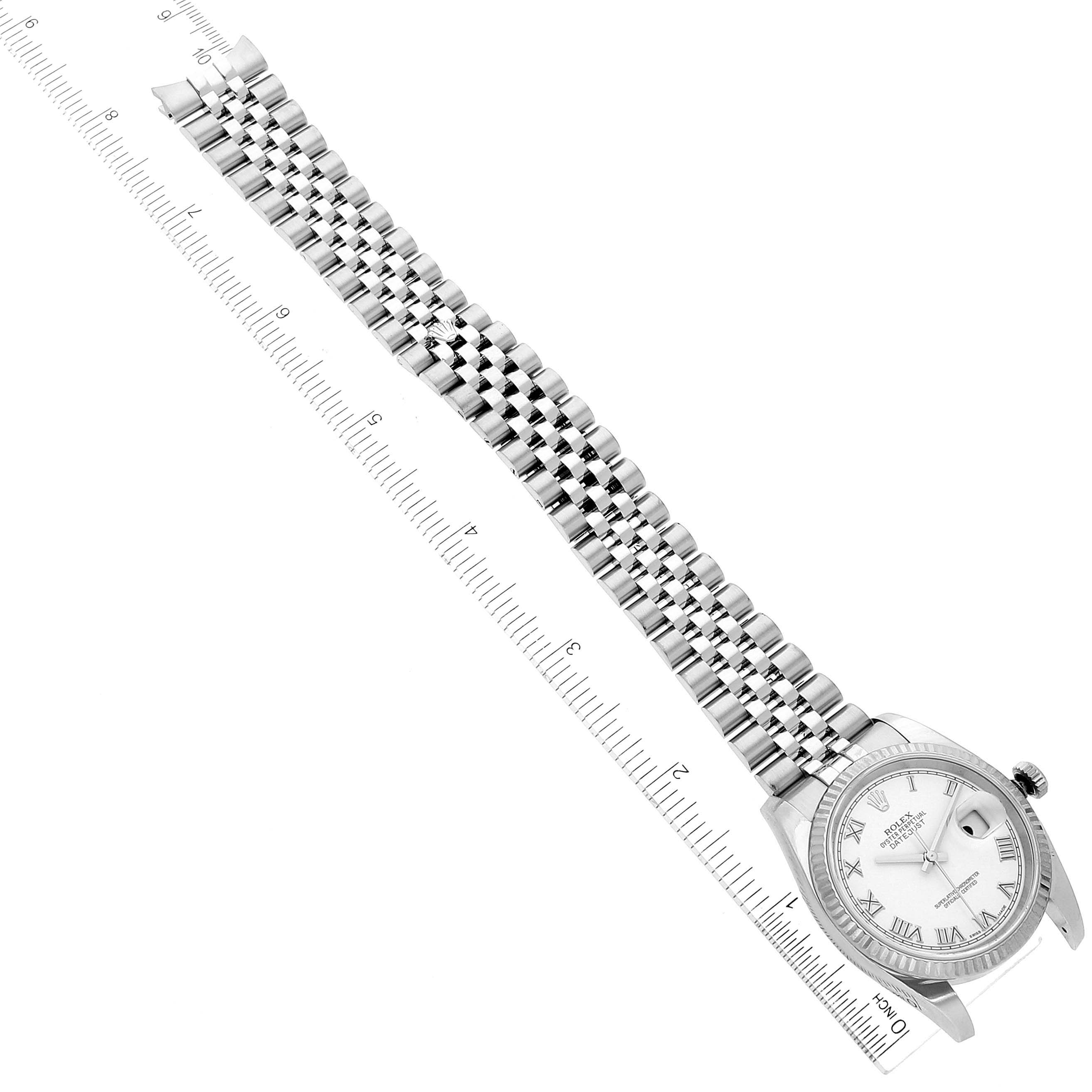This image shows a top-down view of a Rolex Datejust 116234 Men's Stainless Steel White Dial 116234 Men's Stainless Steel White Dial watch, including its dial, bezel, and bracelet, with a ruler for scale.