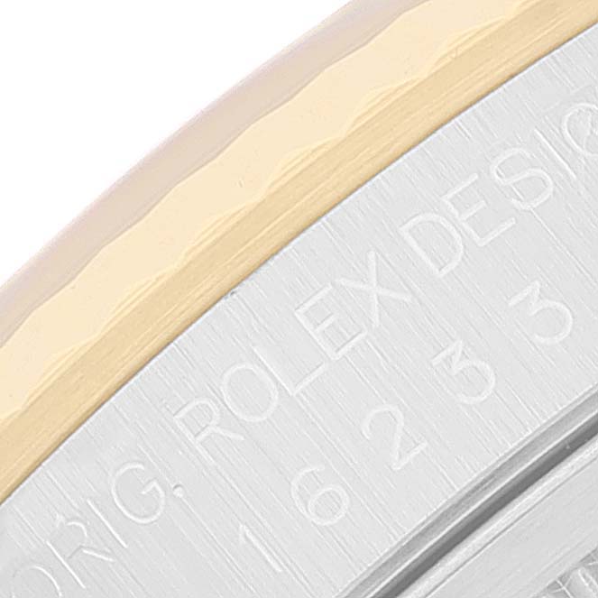 This close-up of a Rolex Datejust 16233 Men's Steel and Gold (two tone) Black Dial 16233 Men's Steel and Gold (two tone) Black Dial watch shows the engraved bezel and edge of the case.