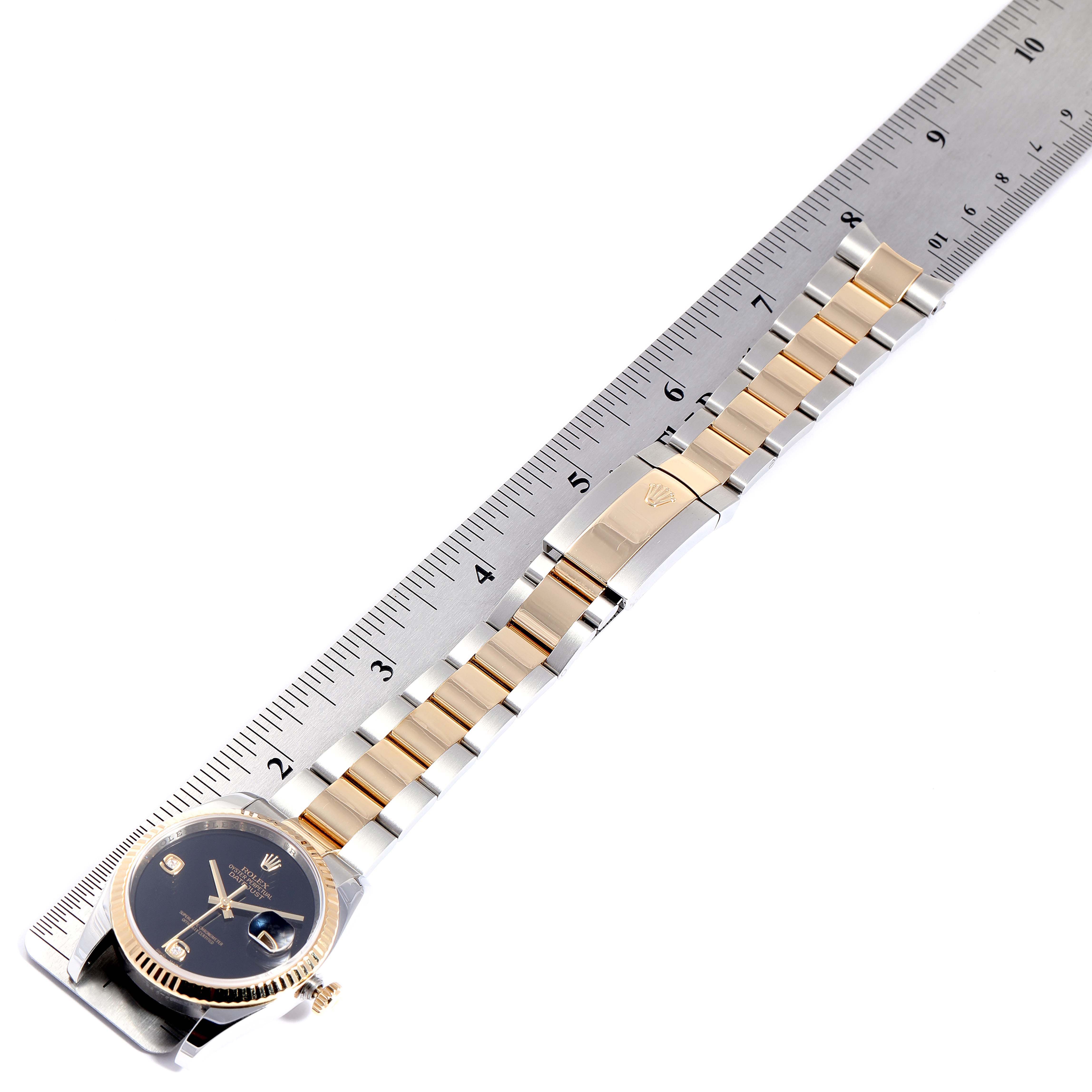 The image shows a top-down view of a Rolex Datejust 116233 Men
s Steel and Gold (two tone) Black Dial 116233 Men
s Steel and Gold (two tone) Black Dial watch with its bracelet measured against a ruler.