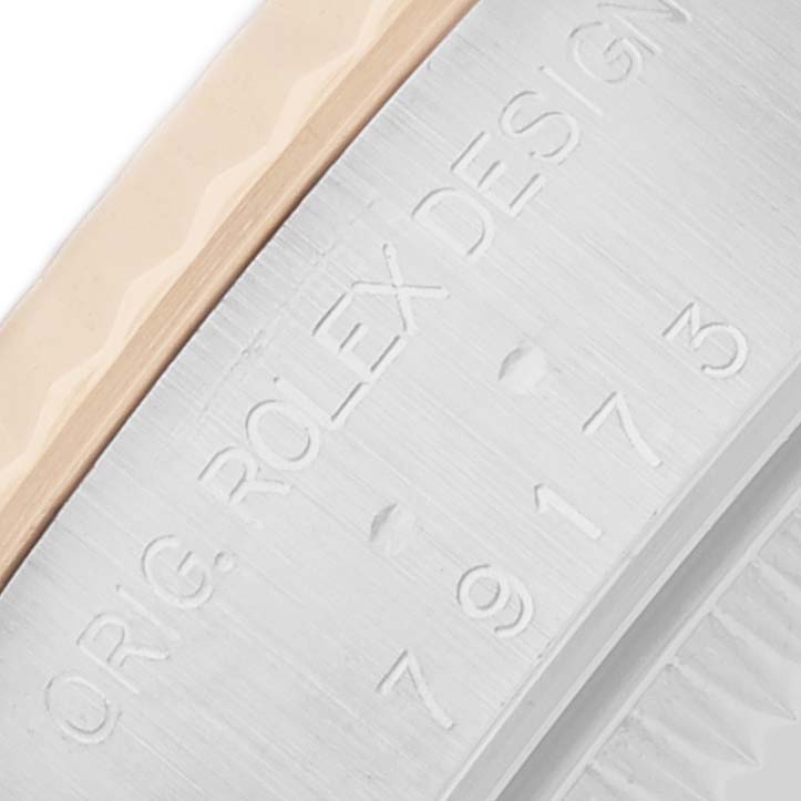 This image shows a close-up of the Rolex Datejust 79173 Women
s Steel and Gold (two tone) Champagne Dial with focus on the bezel and engraved side of the case.